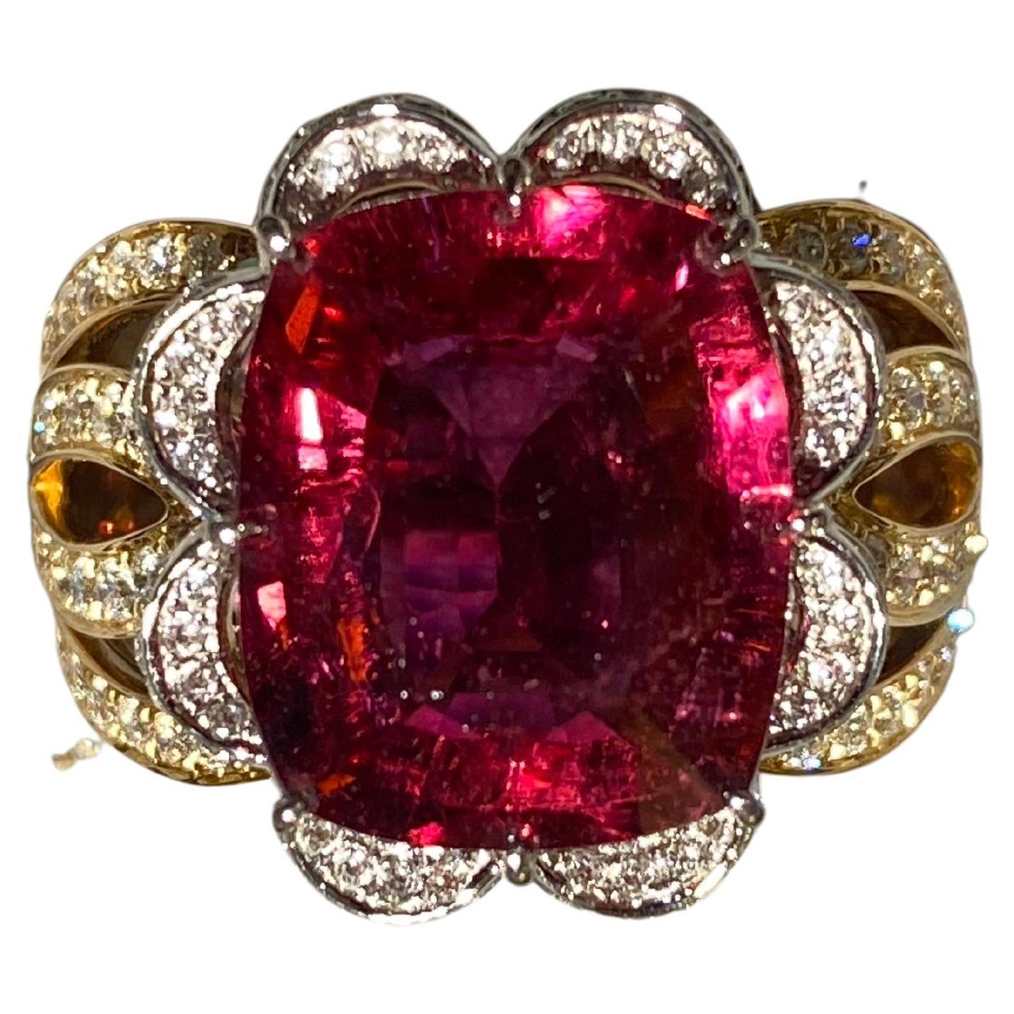 Anillo de turmalina rubelita y diamantes en oro amarillo de 18 quilates. La rubelita rectangular está rodeada por un lazo engastado con diamantes en el centro del anillo. A continuación, todo el motivo de la cinta de rubelita se une a la banda del