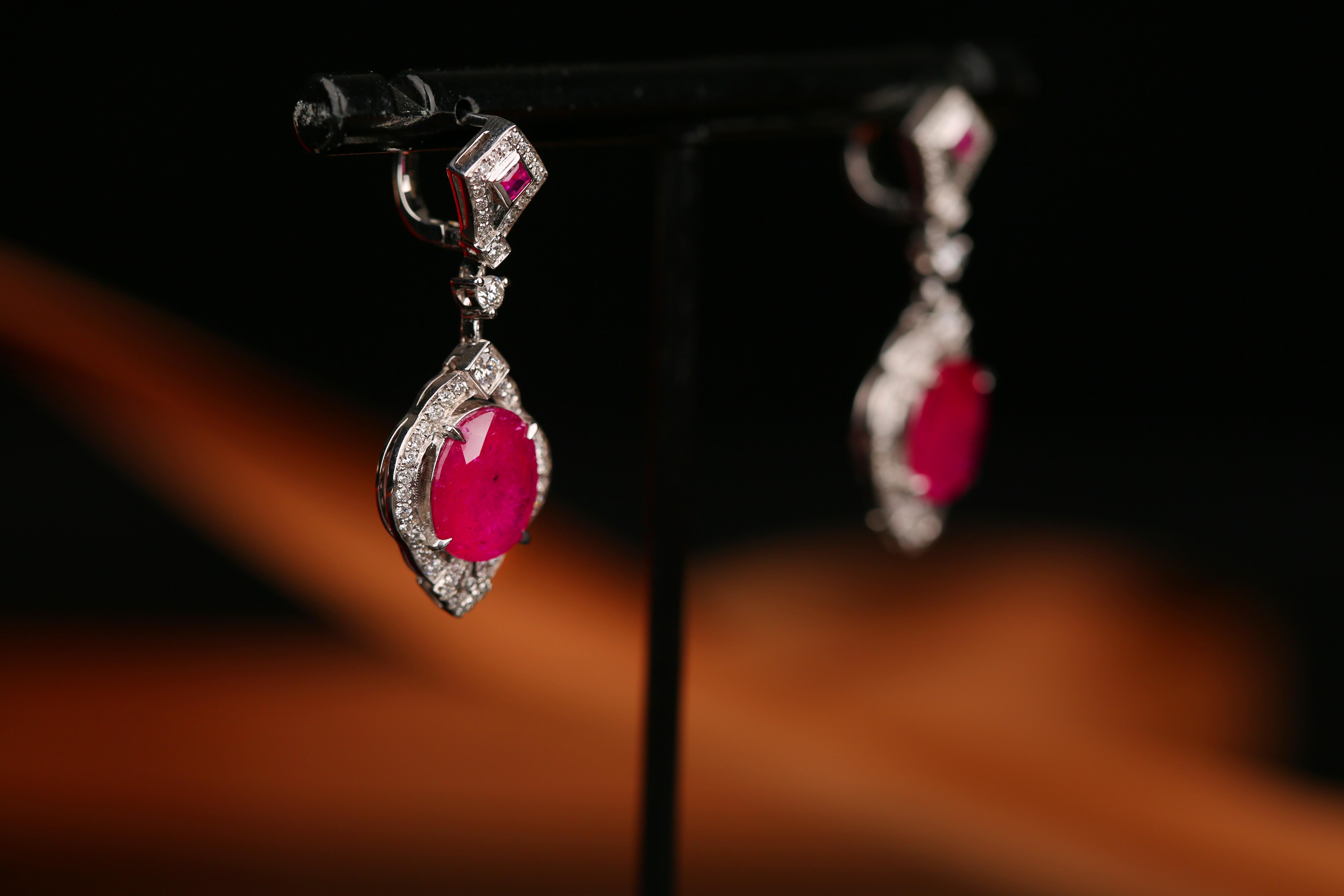 A Pair of unheated Ruby and Diamond ArtDeco 18k White Gold Earring. This pair consists of 4 Rubies, 2 smaller square rubies and 2 larger oval shape rubies. It is of ArtDeco design with kite like Geometric design on top and diamond clustered rubies