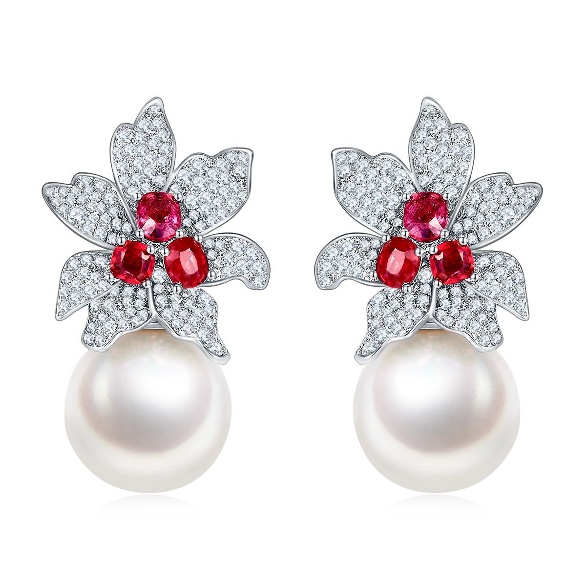 A pair of floral design Pearls earring. 3 pieces of red spinels sitting in the centre of the, diamons encrusted flower petals, on each side of the earring. At the bottom fo the flower comes a lustrous White South Sea Pearl, with the close proximity