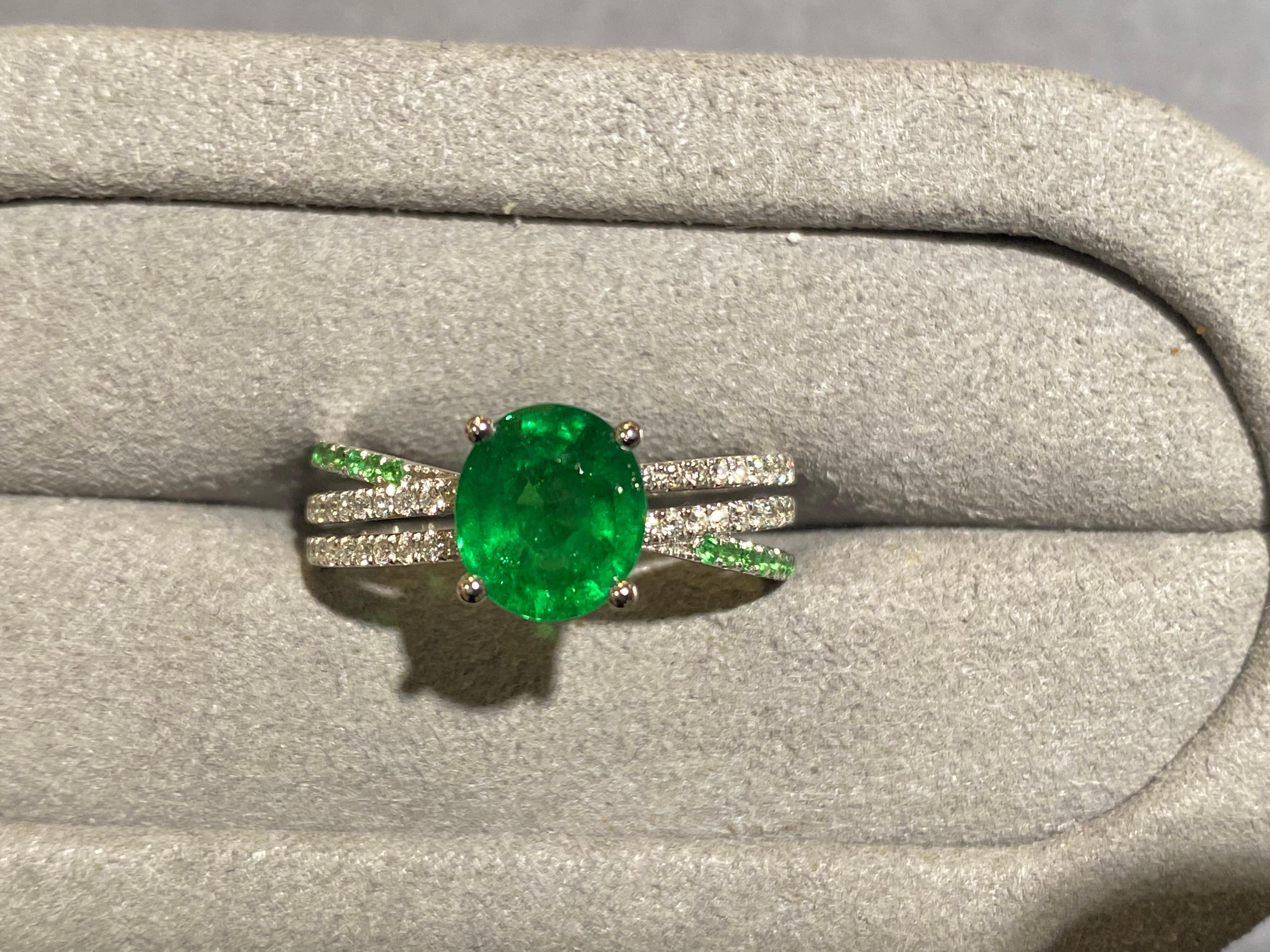 A 1.81 ct Tsavorite and diamond ring in 18k white gold. The main Tsavorite is secured by 4 white gold claws and the band of the ring is made up of 3 individual pave bands. The 2 diamond pave bends are parallel to each other while the tsavorite pave