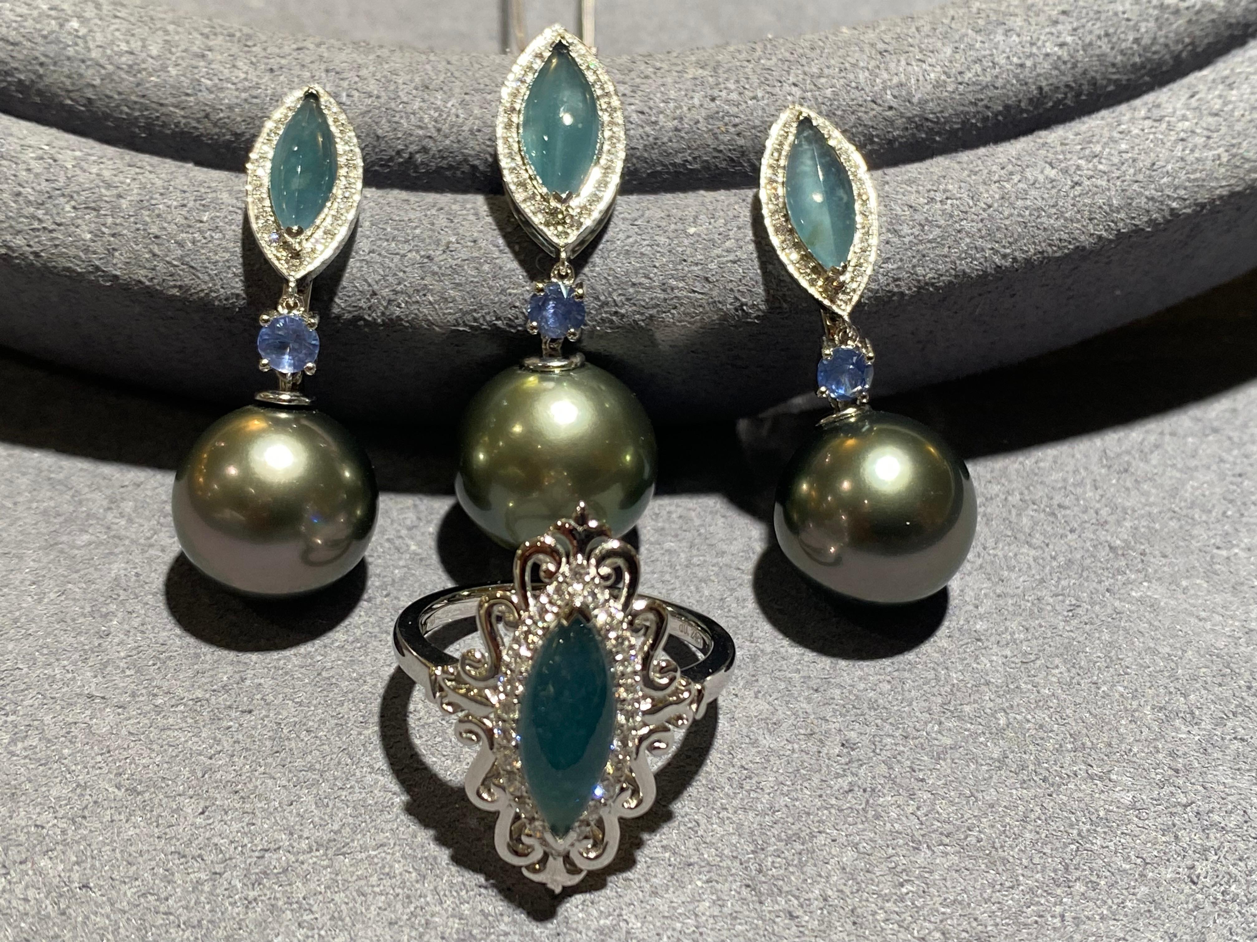 This jewellery set consists of a pair of earrings, a ring and a pendant. They all have a marquise cabochon blue jadeite as the centre stone in this jewellery set.  The jadeite on the ring is surrounded by a circle of micro diamond pave and on the