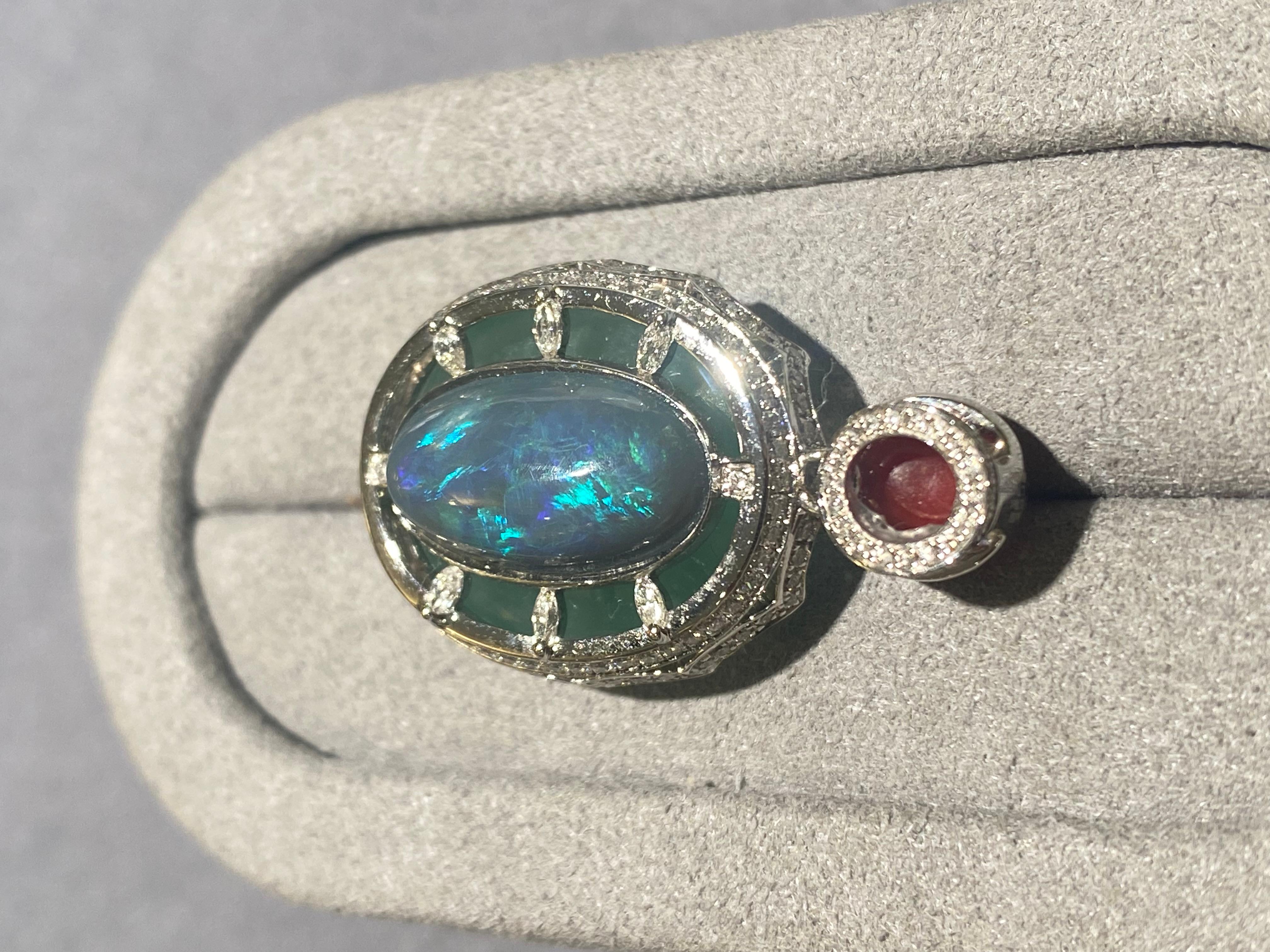 This is a double sided pendant. You can wear it either way depending on the occasions. On one side, it has a large type A green jadeite cabochon with a red coral bale. On the other side, you have a solid opal with diamond pave on the bale. 

Main