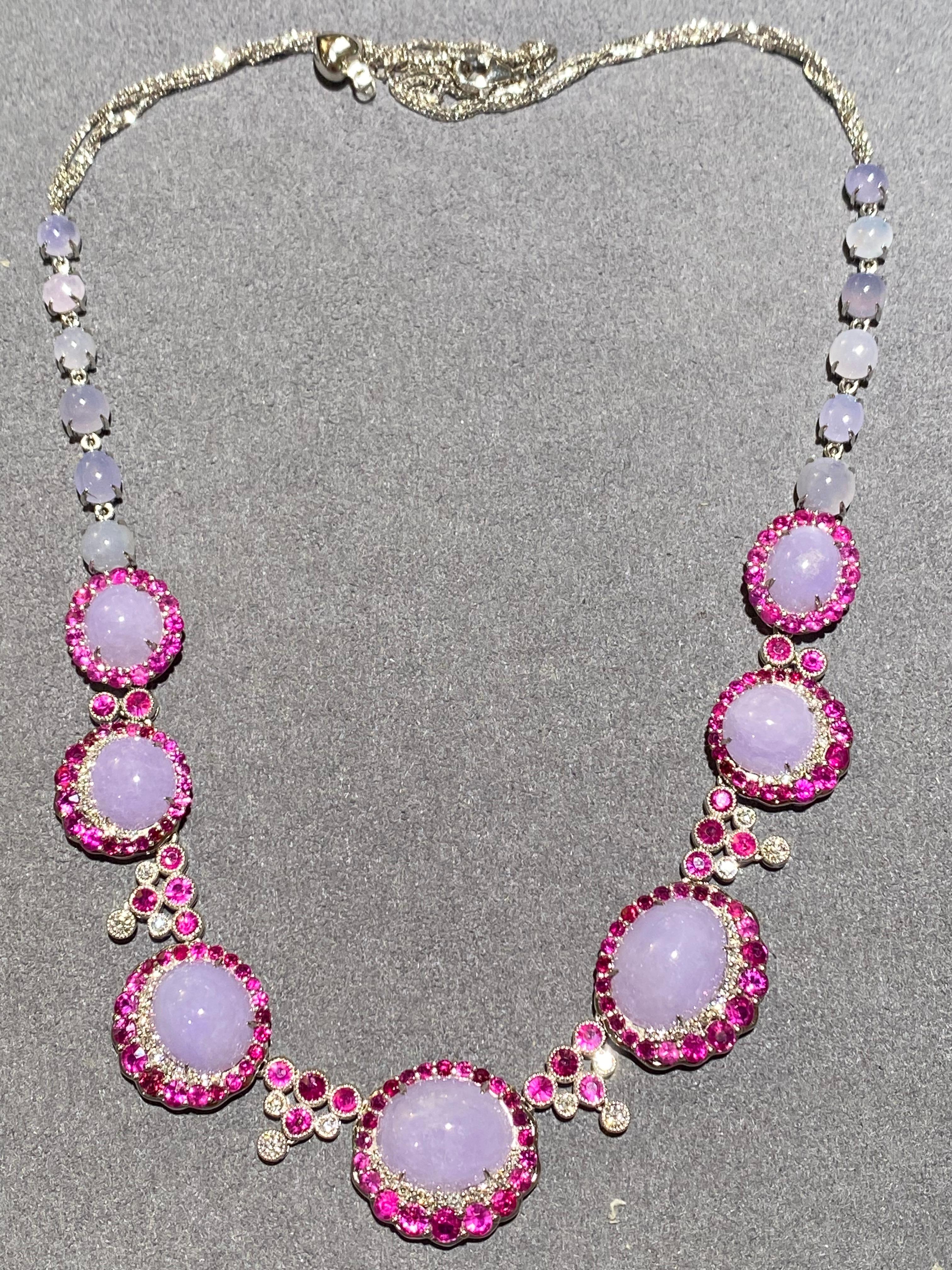An outstanding type A lavender jadeite. ruby and diamond necklace in 18k white gold. The necklace is consists of multiple jadeite cabochons surrounded by diamonds and ruby clusters. The jadeite cluster is then separated from each other by triangle