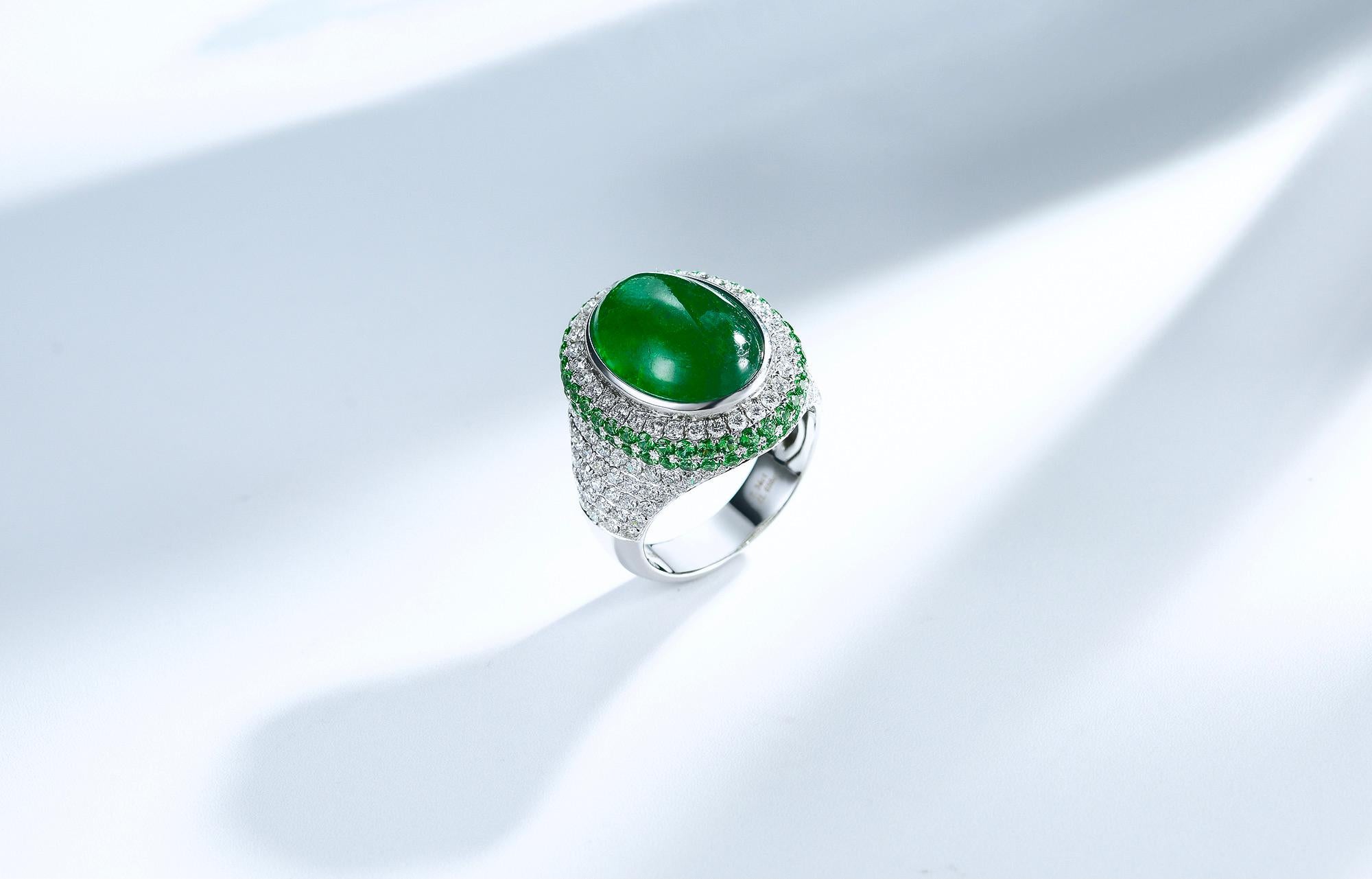 This is a massive statement piece with a 7.34ct Emerald cabochon. The emerald is surrounded by Diamonds and Tsavorite pave, the pave covers half of the ring starting from the top where the Emerald is through to the belly of the ring. It can be wore