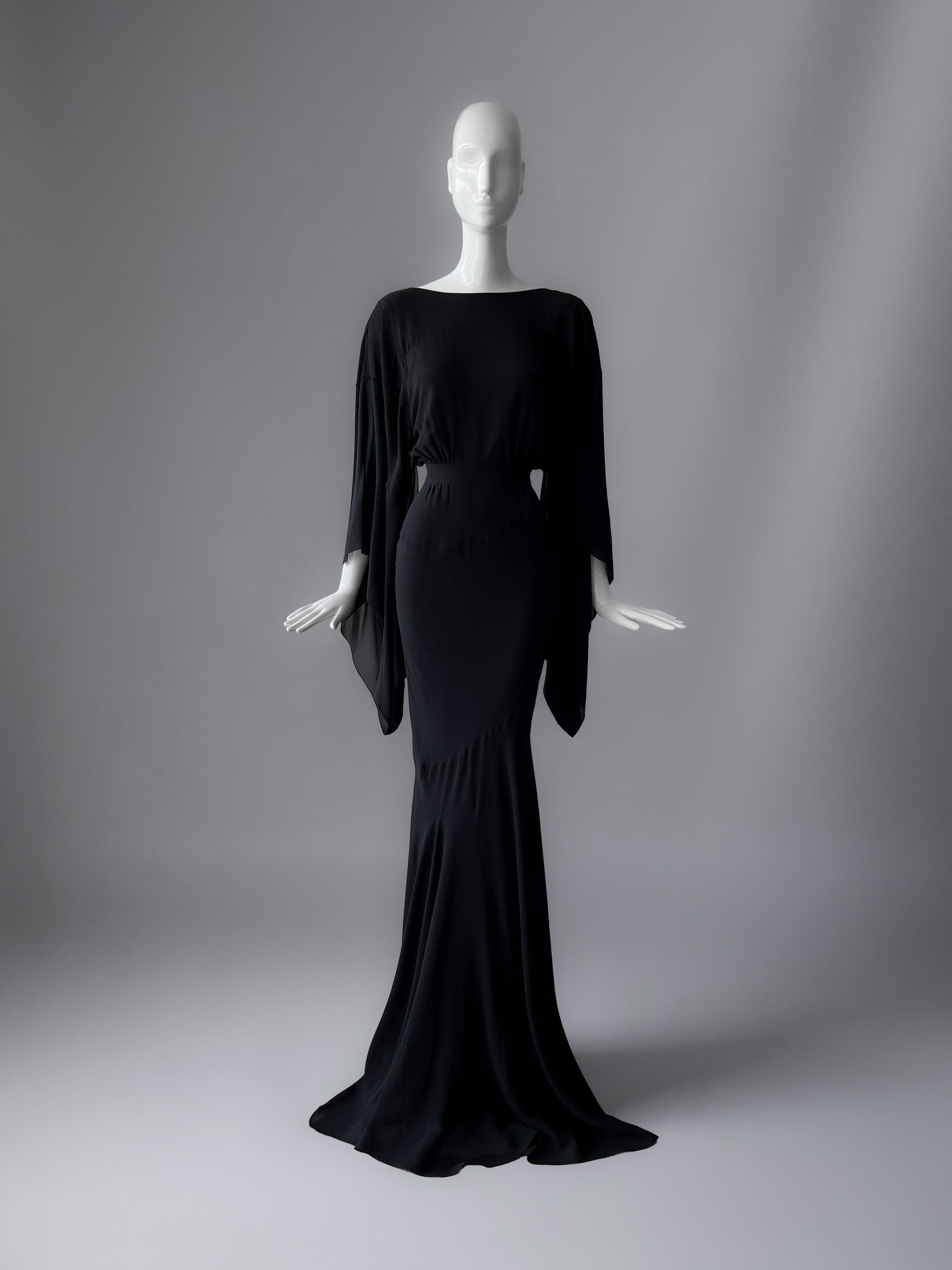 Dieses schwarze Seidenabendkleid von John Galliano aus seiner Collection'S Herbst/Winter 08/09 ist einer dieser Momente: ein Liebesbrief an die Kunst der Couture in ihrer theatralischsten und raffiniertesten Form.
Galliano, der romantische