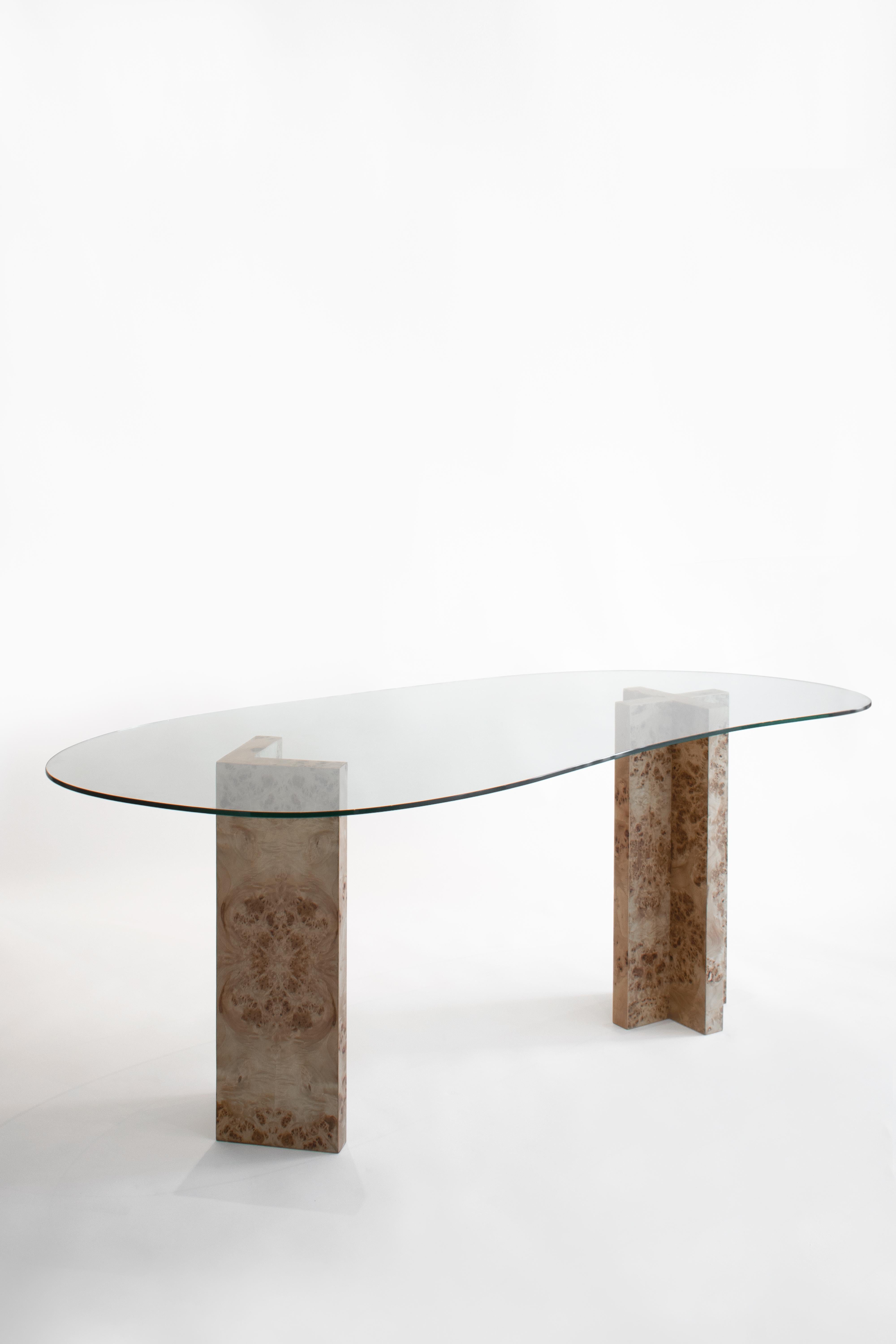 This dining table combines two seemingly opposing strategies, the robustness of its vertical supports with the lightness of its horizontal surface. The two pilas appear as extruded profiles of two typical line intersections, the cross and the right