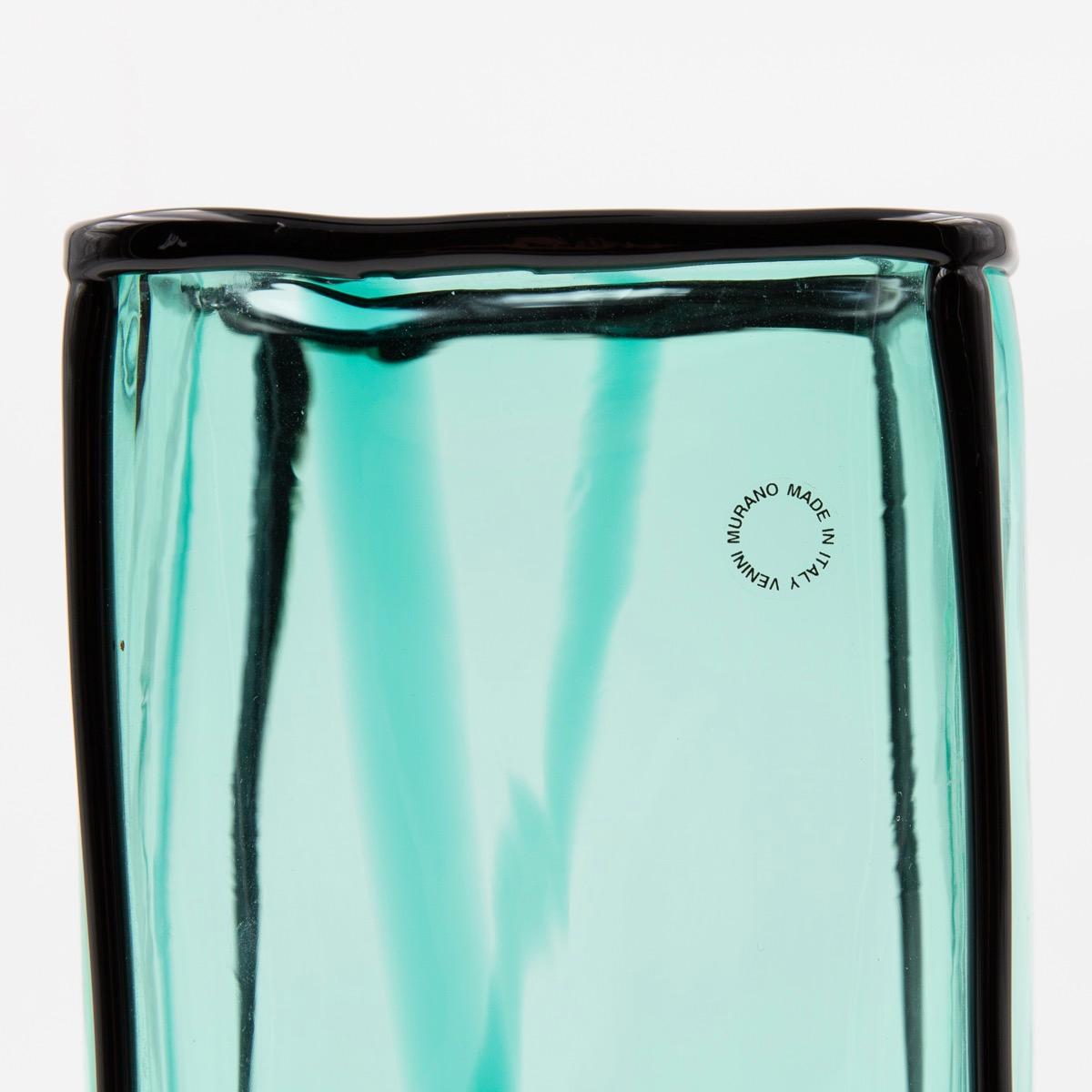 Epipedos is the result of the last series of vases designed by Fulvio Bianconi for Venini at the end of the 80s.It is a large vase in hand-blown glass, geometrically shaped, the contours of which are highlighted with an application of black glass.