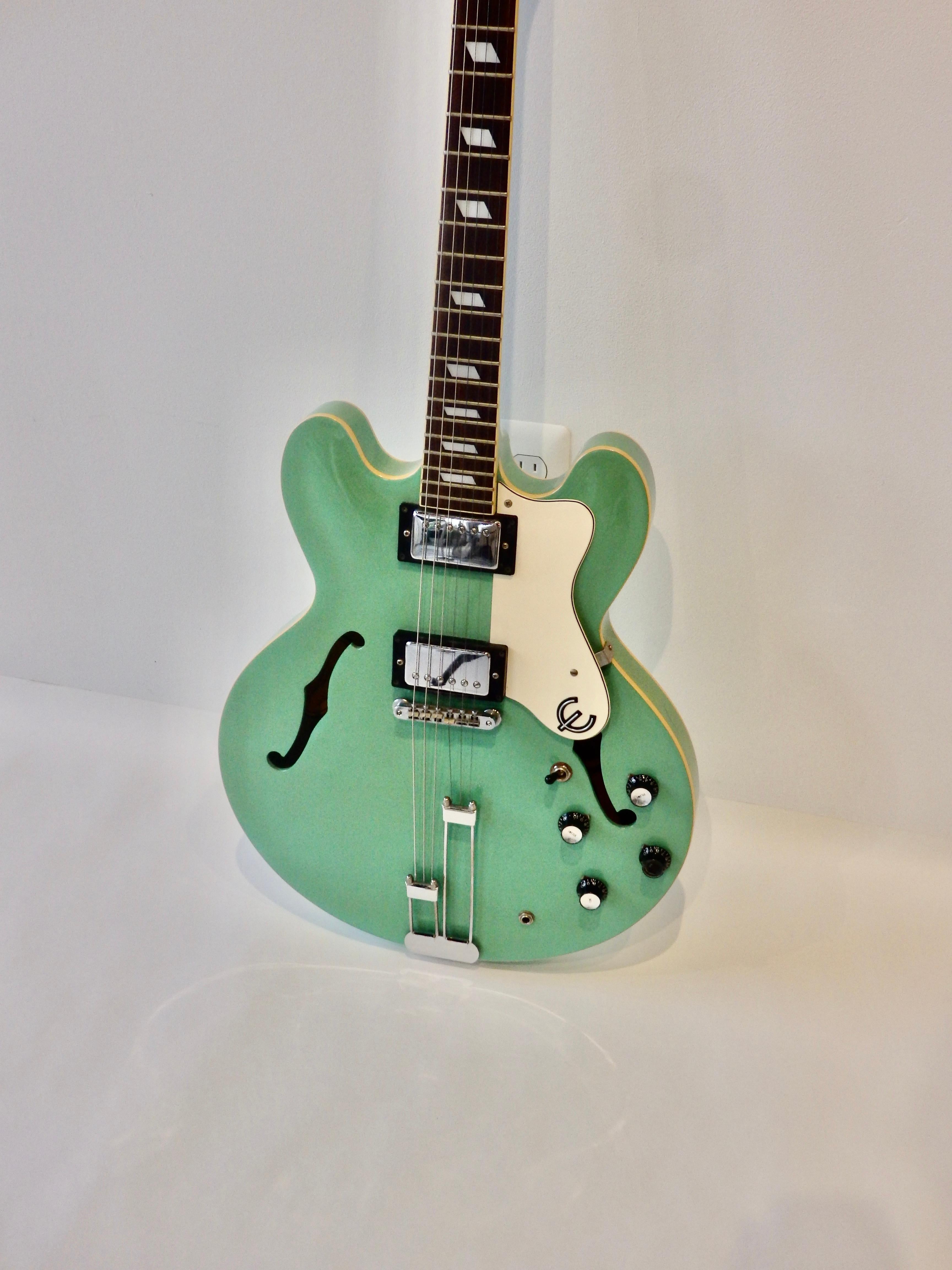 1996 Epiphone Riviera electric guitar with original case. Mint chocolate chip green. Produced at Peerless, Korean Factory, June 1996, serial number R96P1415, Humbucker pickups, hardshell case, amp power cord. Working condition. 1 and 5/8 nut at top