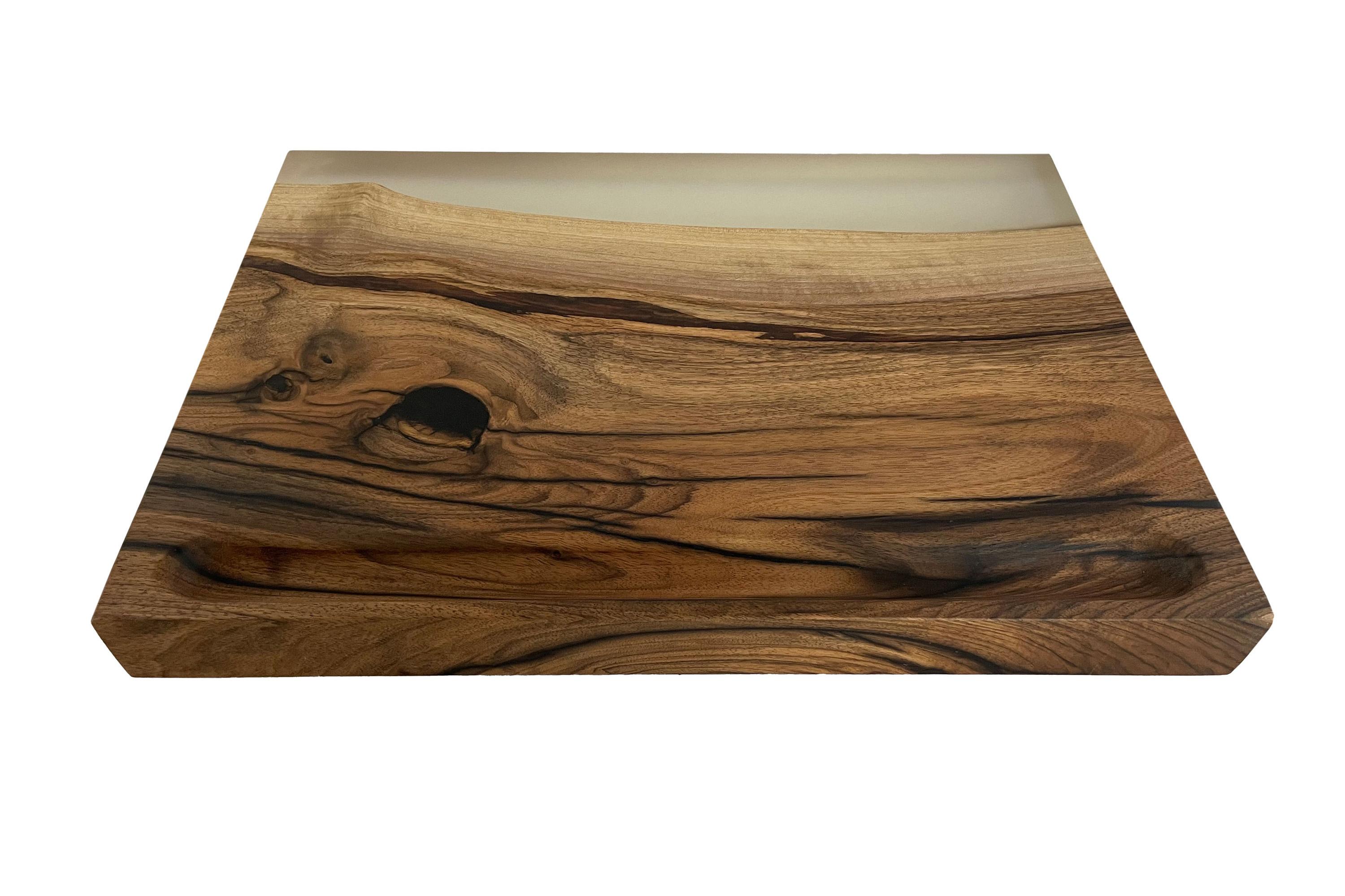 American walnut cutting board. The walnut was glued in multiple layers and cracks, knots, etc. were filled with high-quality epoxy. The surfaces are very finely ground and sealed with oil. A very large and gently tapering depression is milled into
