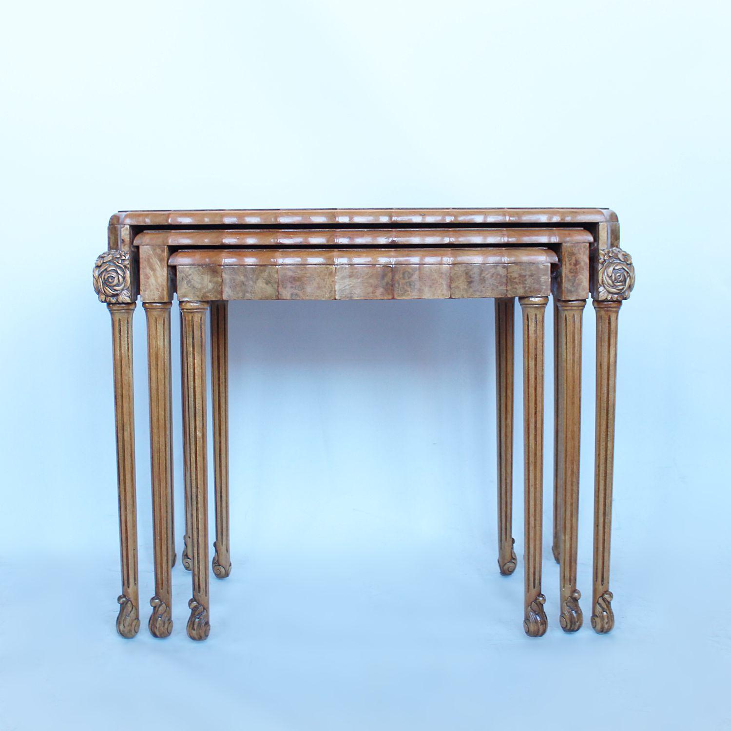 An Art Deco nest of three hanging side tables. Bow fronted with fluted shape. Set over tapering legs with scrolled feet and carved corner details. Burr walnut throughout with solid walnut legs and banding.

Dimensions: H 58cm, W 72cm, D 40cm,

H