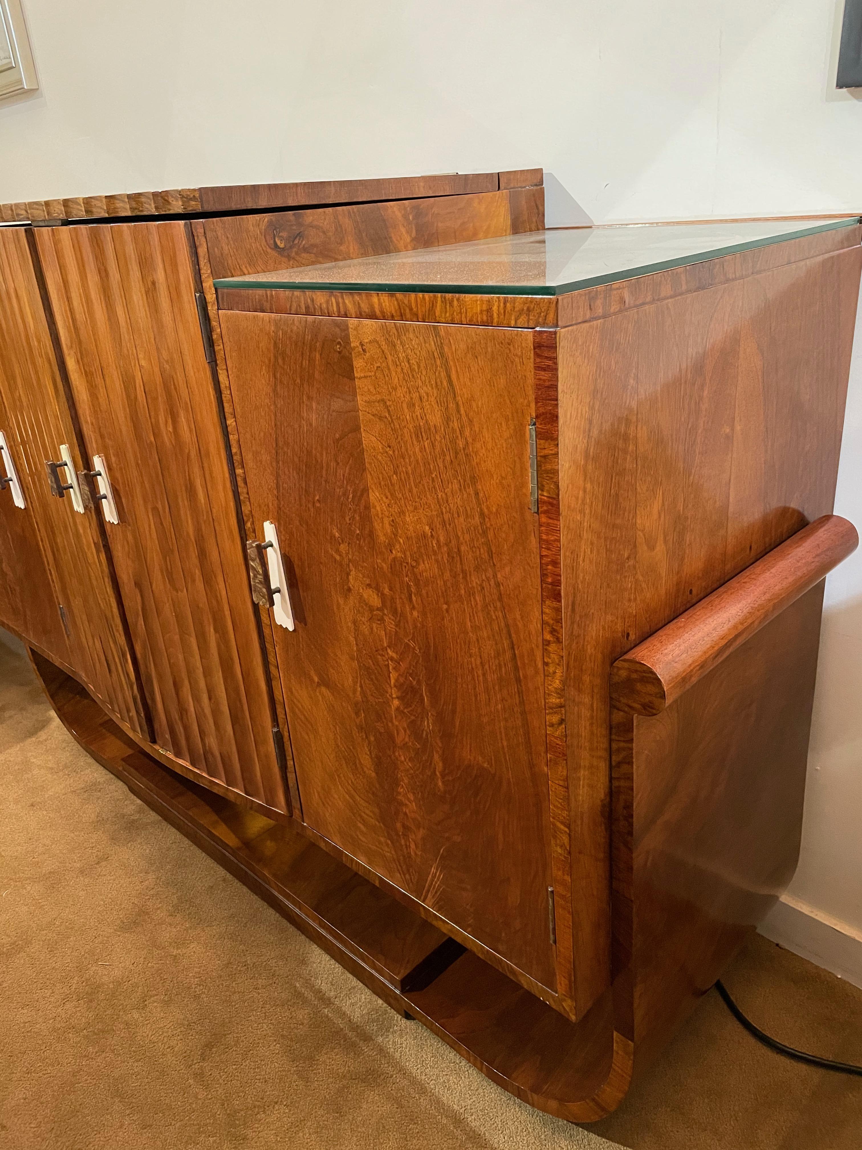 This stunning Epstein bar is Art Deco at its finest. One of England’s premier art deco furniture manufacturers, this restored walnut wood with maple wood interior is the finest quality you will see. Rich honey color offset with original bakelite