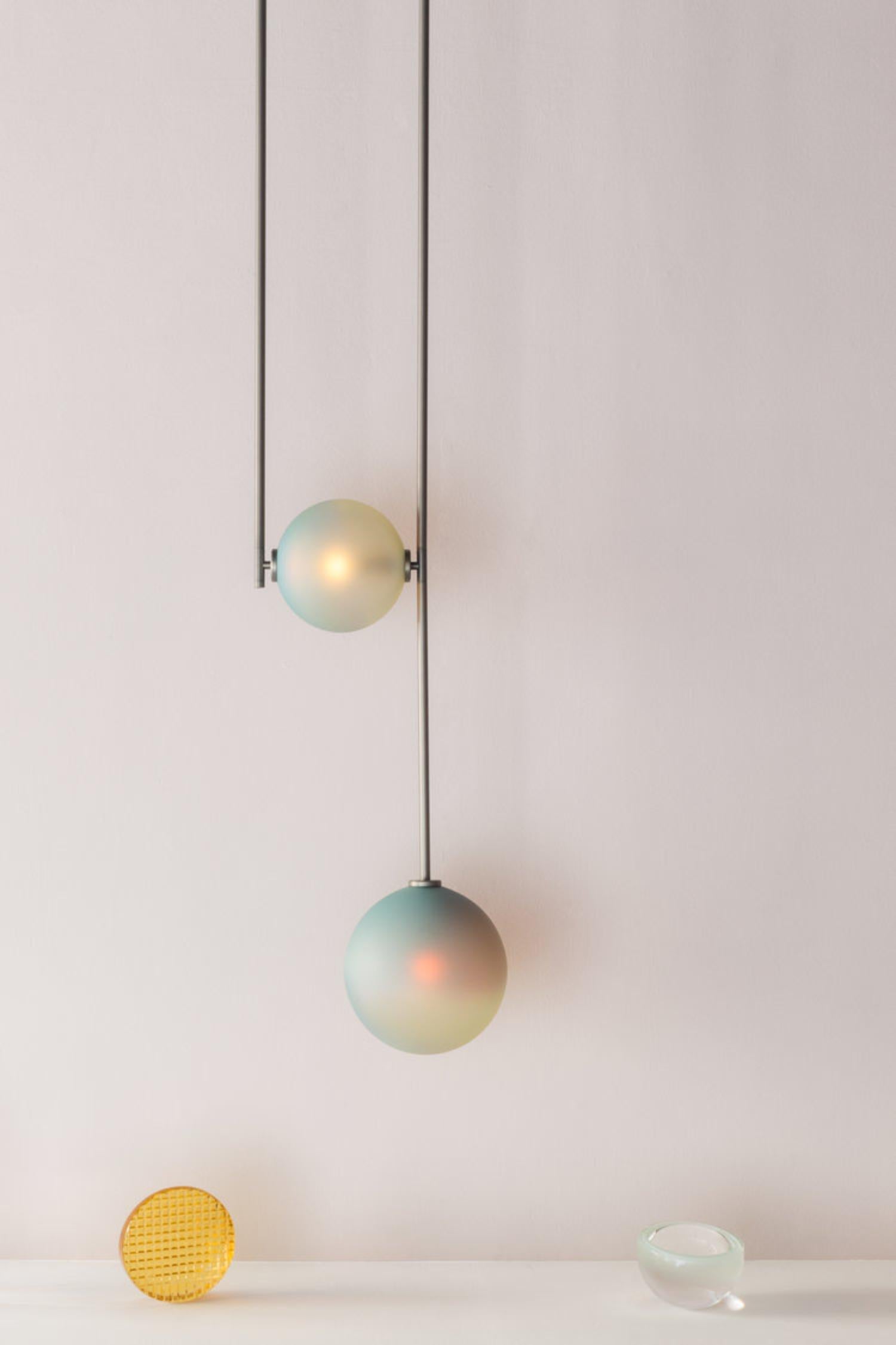 Equalizer chameleon globe pendant light by Ladies & Gentlemen Studio 
Dimensions: Height variable, 12” round canopy
Materials: Copper, brass, wire, cord
Finishes: Black anodize/bronze 
 Anodize/olive anodize
 Glass: cream/smokey green/chameleon

All