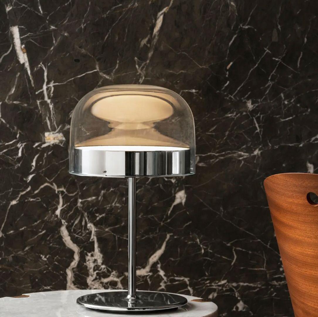 Equatore is a contemporary reinterpretation of the classic lamp with a glass shade. While the traditional abat-jour uses the shade to contain the light source within, in this family of lamps the shade is paradoxically and suggestively empty, with