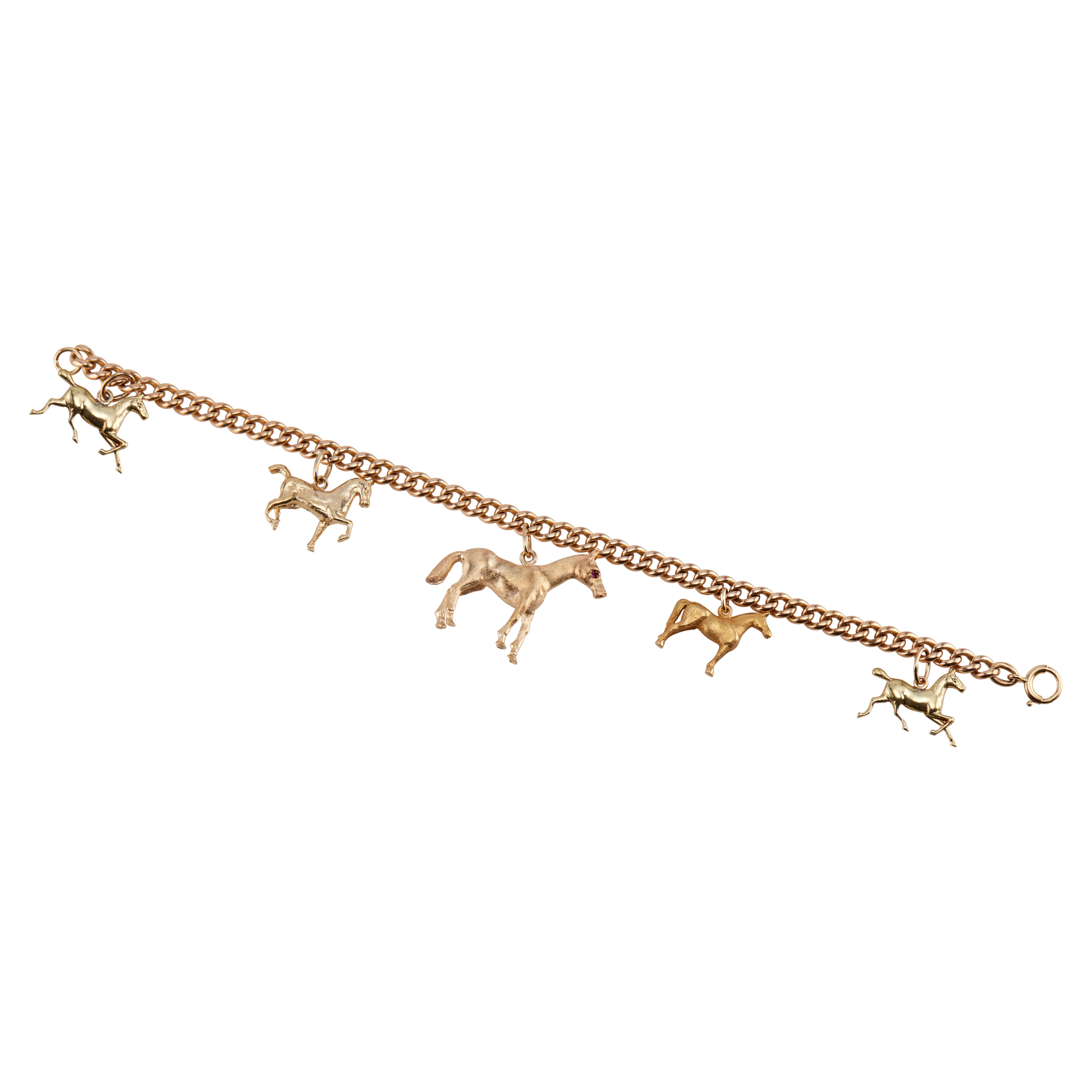 1960's Five charms, two and three dimensional solid 14k gold horse charms on a solid 14k rose gold bracelet. 7 inches in length. 

14k yellow gold 
14k rose gold 
Stamped: 14k
29.4 grams
Depth or thickness: 6.6m - 1.6mm
Bracelet: 7 Inches
Width:
