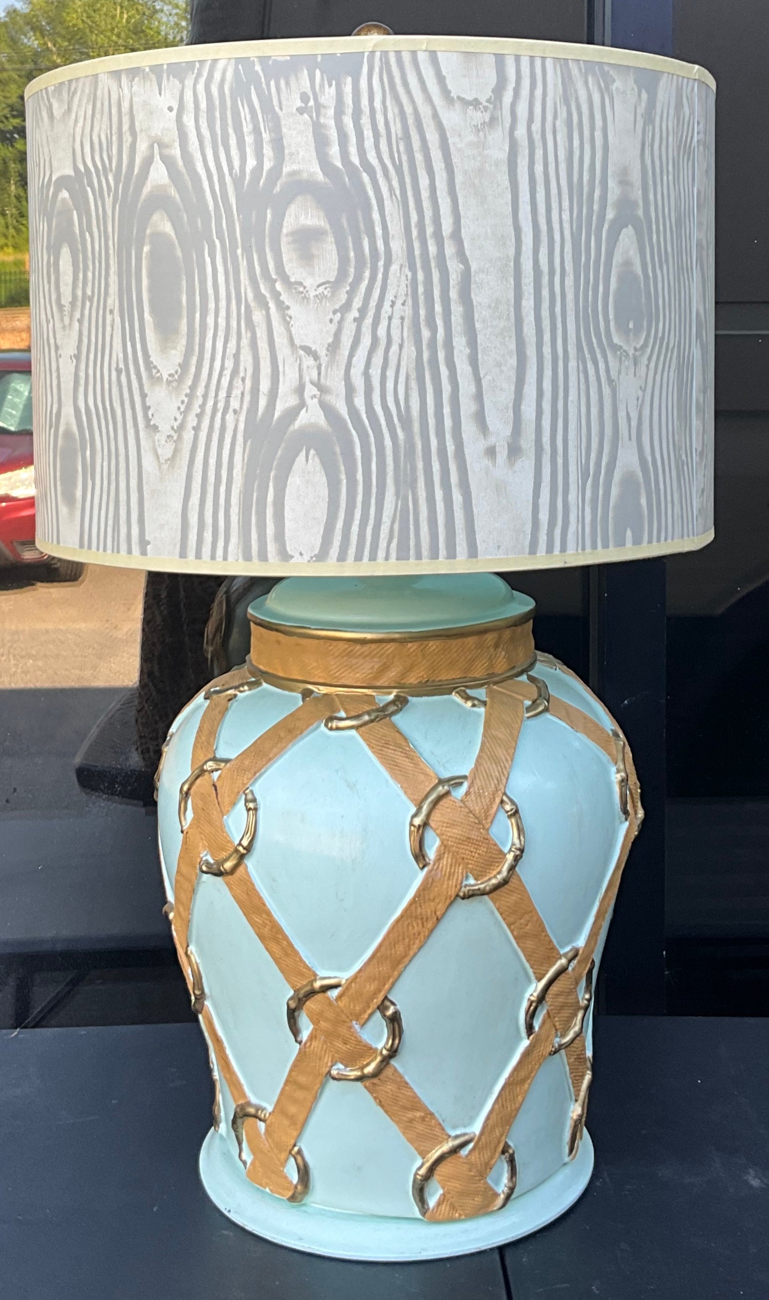 I love this lamp! It is an equestrian inspired lamp with faux bois drum shade. It is a large ceramic base with faux bamboo rings woven with a faux canvas ribbon. The shade is paper with a faux bois theme. Sadly, there is a slight dent. The color is