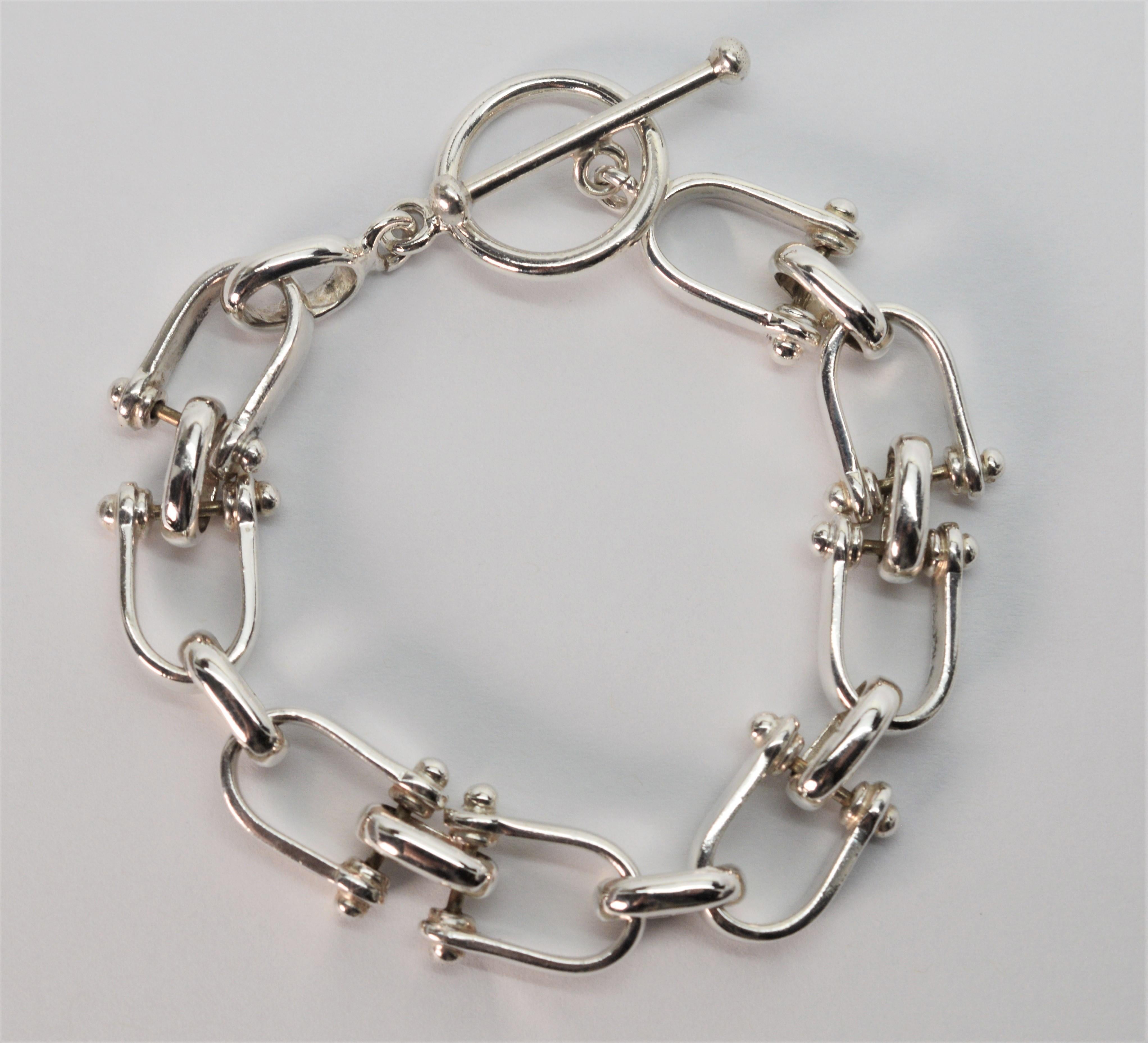 In sterling silver, the unique stirrup shaped links accentuate the hardware look of this equestrian inspired bracelet. 
Fitted with a large, easy toggle clasp, the bracelet length is 7 inches.  Gift boxed.