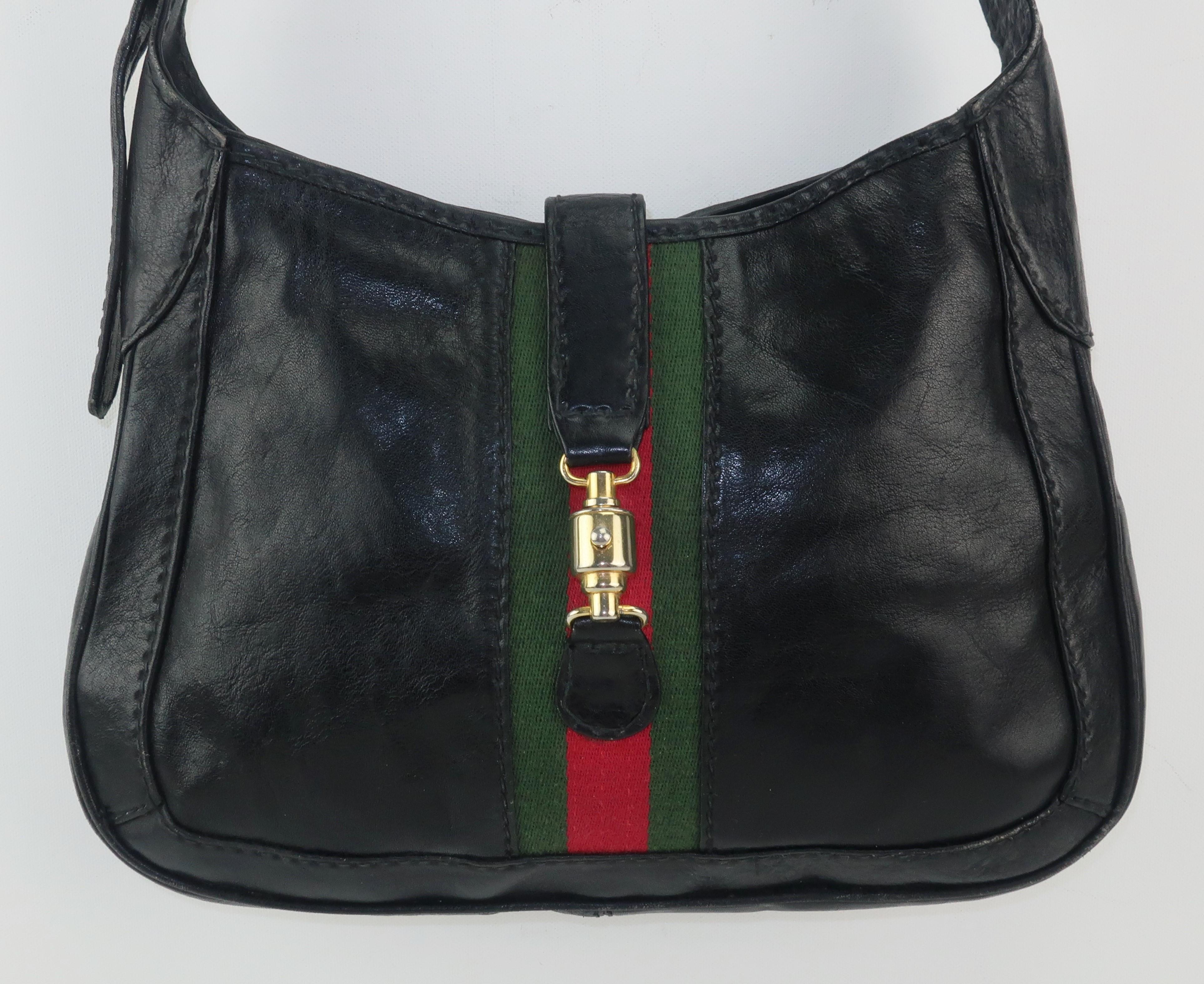 C.1970 Neiman Marcus Italian black leather handbag with a Gucci style red & green stripe accent.  The unique gold tone closure has a push button release and a decidedly equestrian look.  The shoulder strap is adjustable and the roomy interior is
