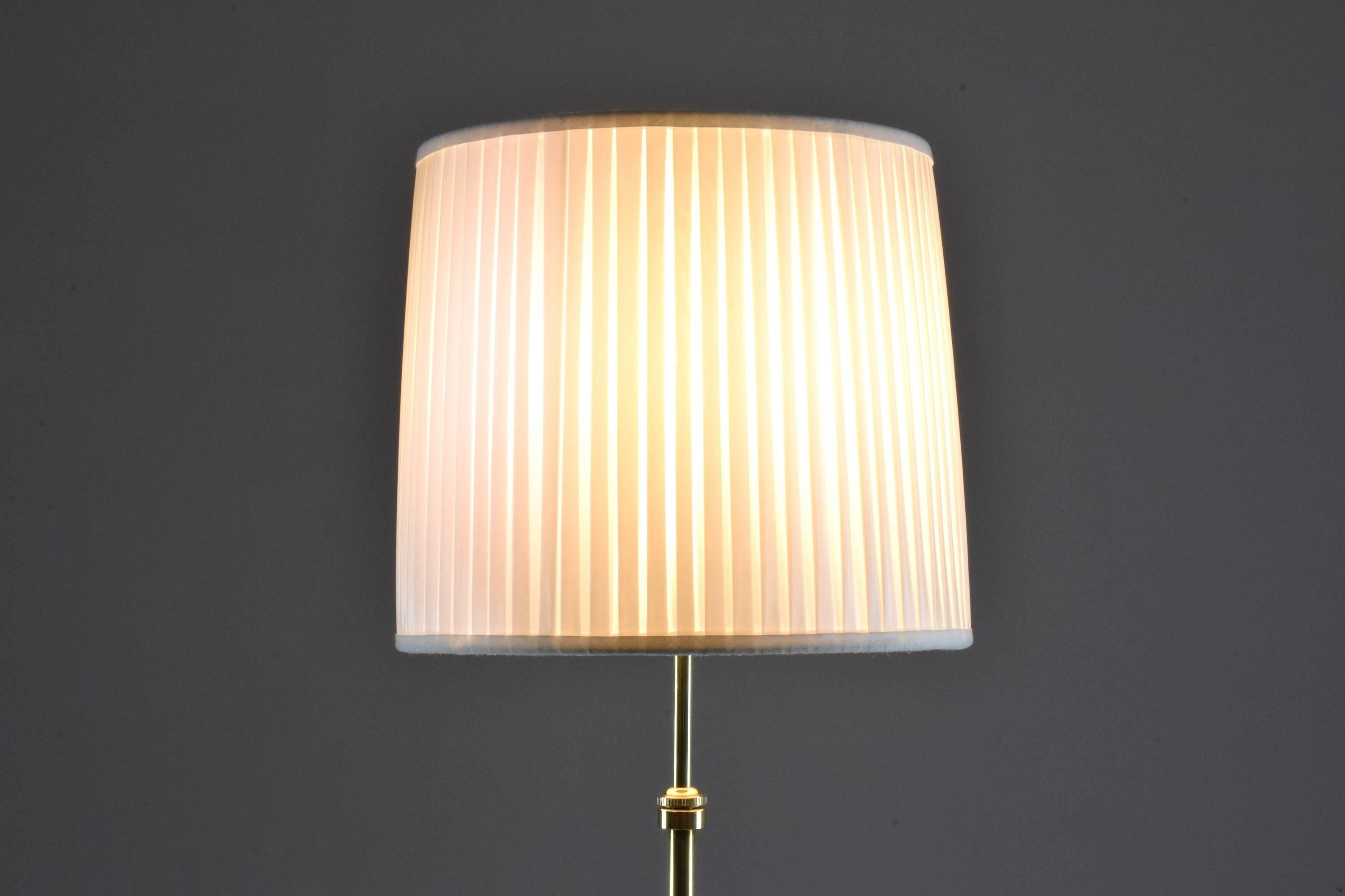 Contemporary handcrafted floor lamp composed of a solid brass structure -pictured here in a polished finish - which adjusts in height and is designed with a pleated white fabric lampshade. 

Flow collection, Equilibrium-I model II
21st century