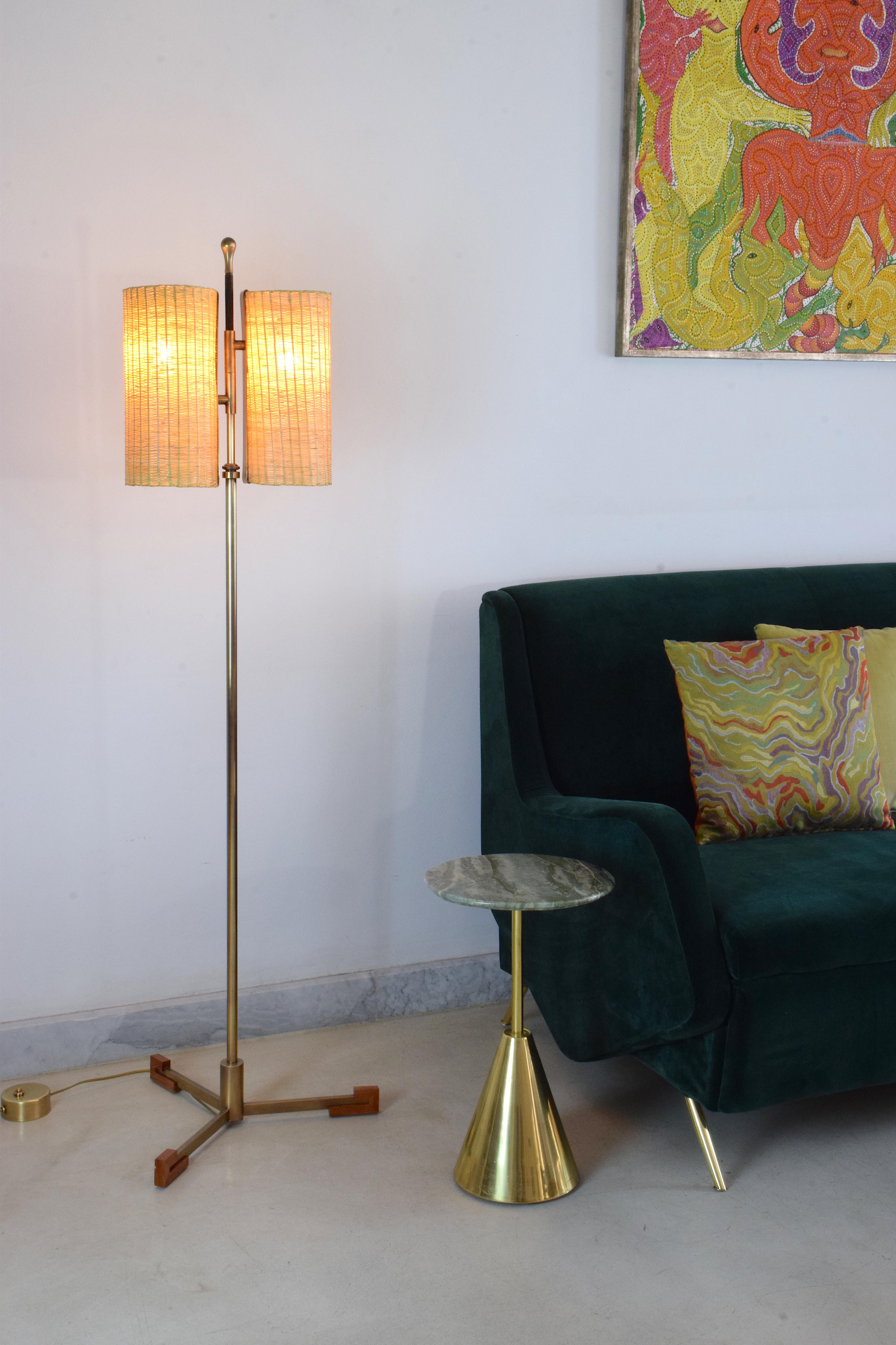 Contemporary handcrafted floor lamp composed of a solid polished brass structure which adjusts in height, a leather detail hand-pleated by artisan saddle makers, a walnut tripod base, and two handwoven wicker cylinder lampshades. 

Flow