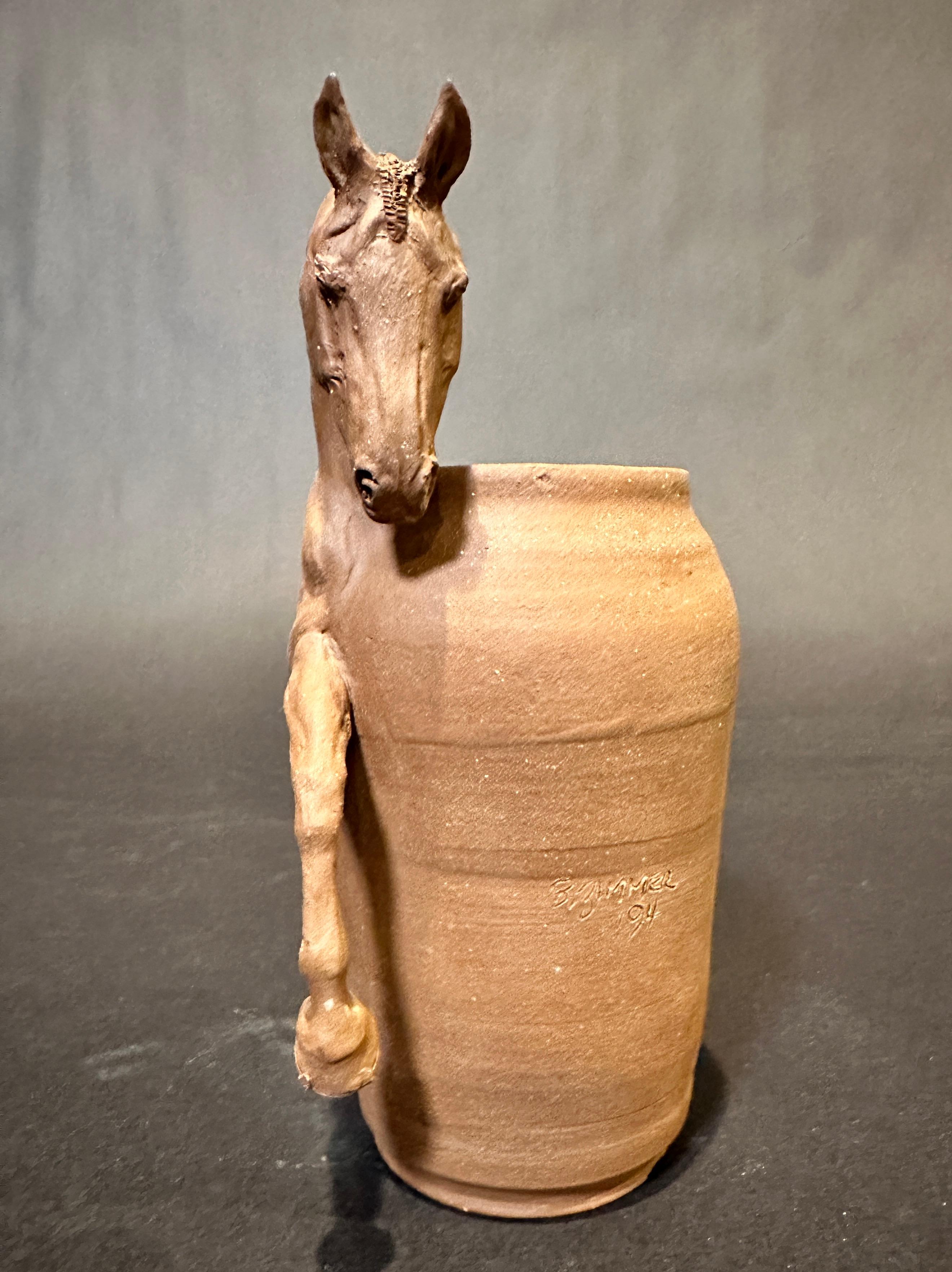 Vase original en grès de Beverly Zimmer représentant un équidé. Magnifique vase sculptural en argile cuite représentant un profil de cheval athlétique.
Depuis le début de sa carrière, l'industrie du cheval de sport a été la cible de Beverly Zimmer.