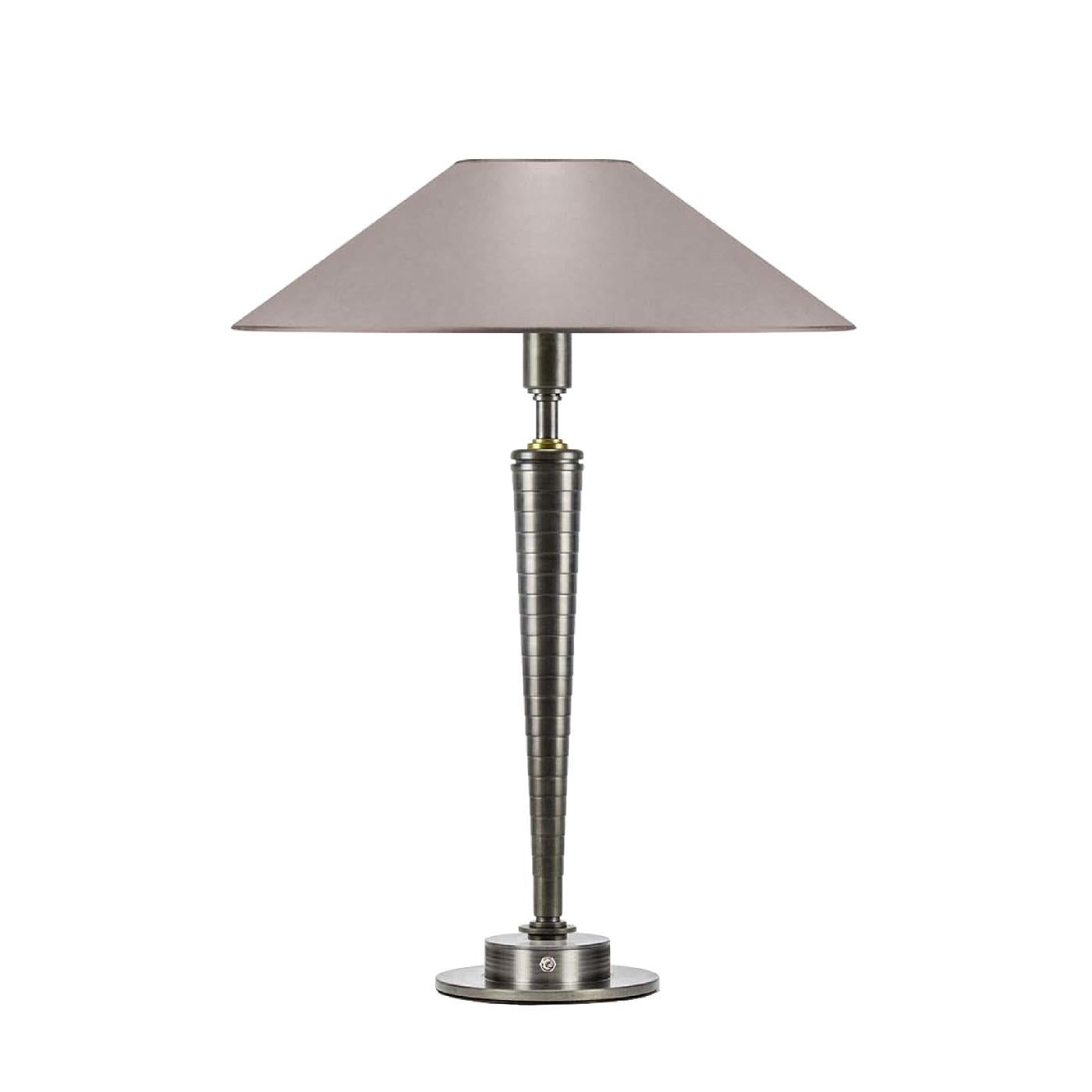 The perfect choice to add a touch of timeless elegance to any room, this table lamp will bring glow and glamour to any decor. The clean-lined silhouette is entirely handcrafted of steel with a round base and a conical stem that pairs well with the