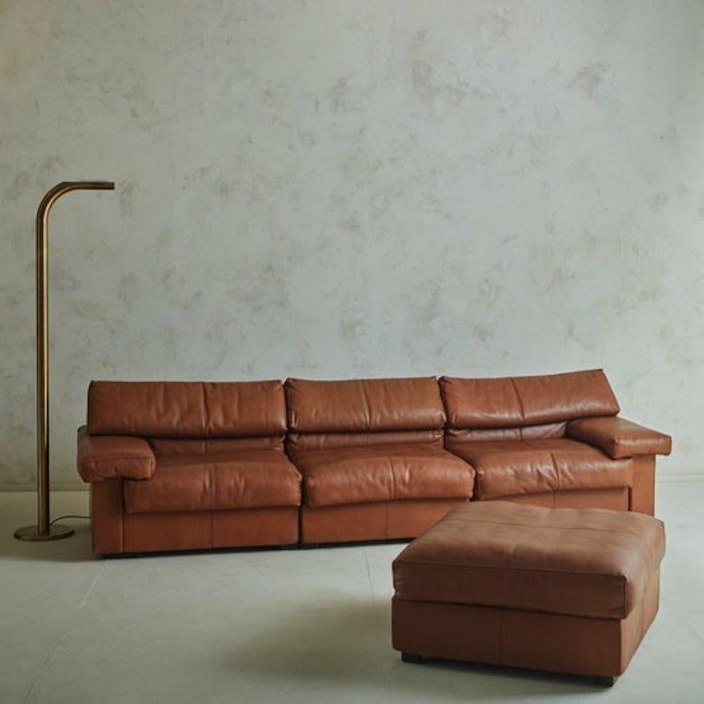 A three-section modular ‘Erasmo’ sectional sofa designed by Afra + Tobia Scarpa for B&B Italia in the 1980s. This handsome sofa retains its original patinated leather cognac leather upholstery with stitch detailing. It features wide seats and