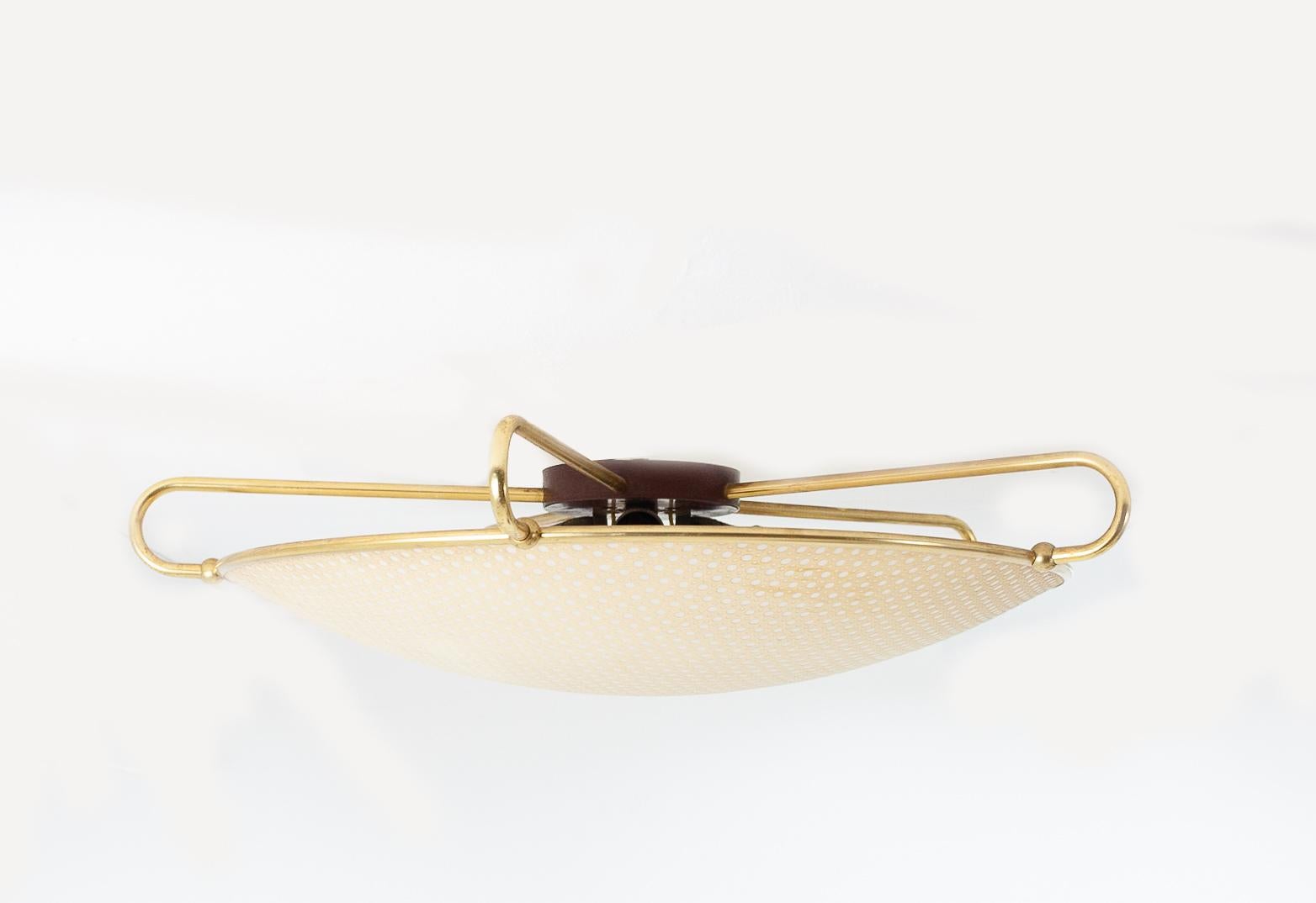1960s ERCO ceiling light features a bakelite ceiling plate and triple armature, elegantly curved brass arms and a translucent plastic shade. This example is in very nice shape.