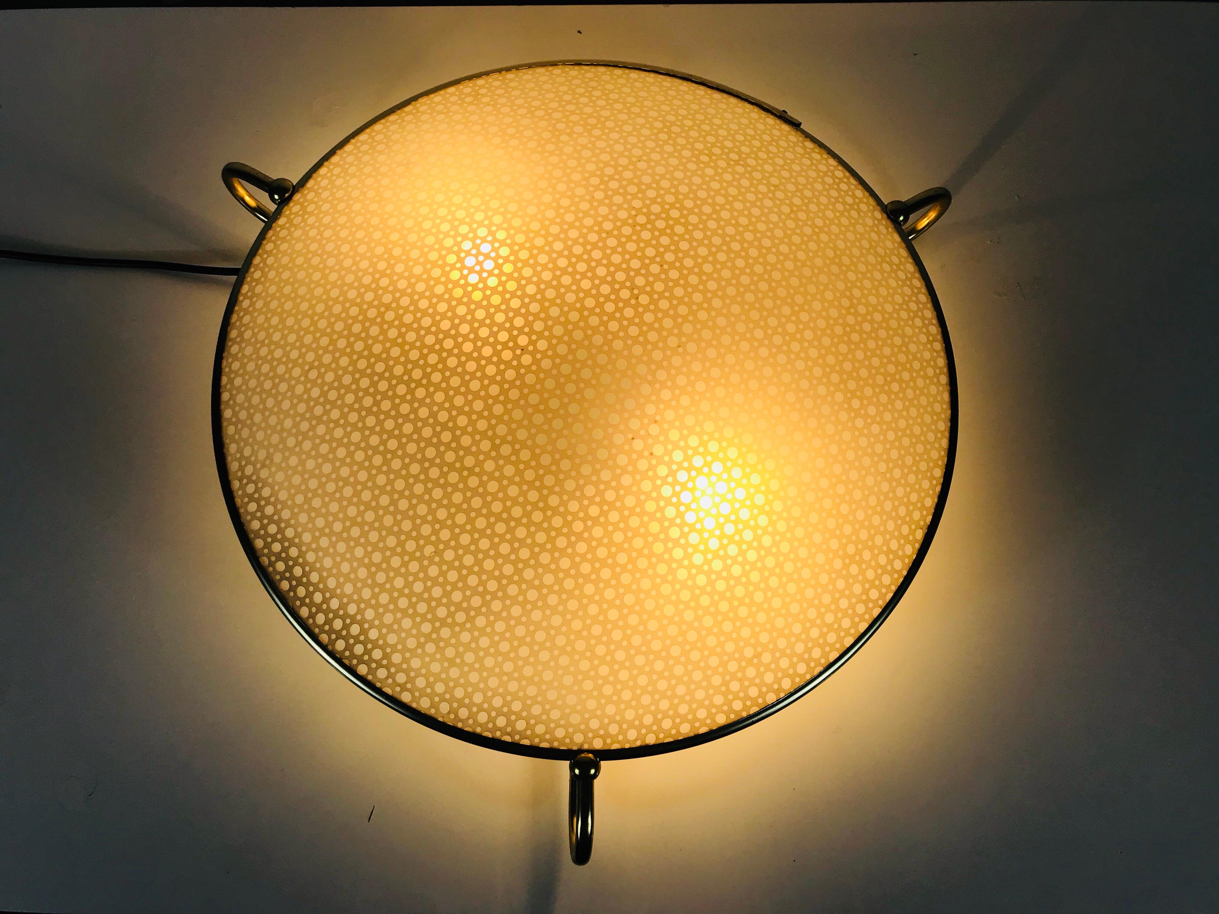 A midcentury flush mount made in Germany in the 1960s. It is fascinating with its rare plastic shade which is surrounded by a brass frame. The shade is arched outside. The sockets are made of bakelit. 

Measurements:

Height 10 cm

Diameter 51