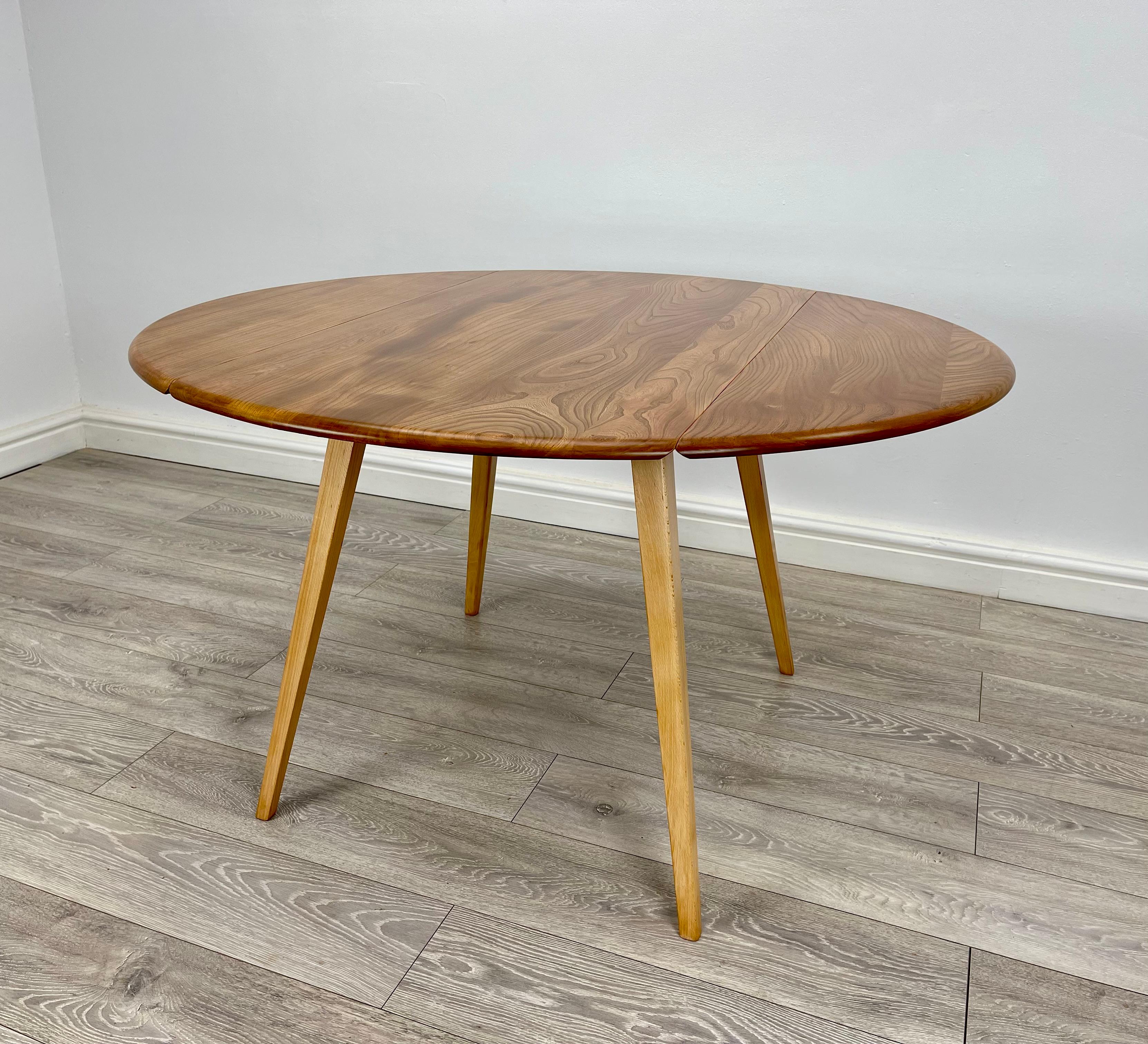 DINING TABLE 
Mid-century elm and beech drop leaf dining table made by ercol circa 1960 . 
The table has solid elm top with stunning grain Grain throughout , the legs are made from solid beech . 
The table can be easily stored away once the leafs