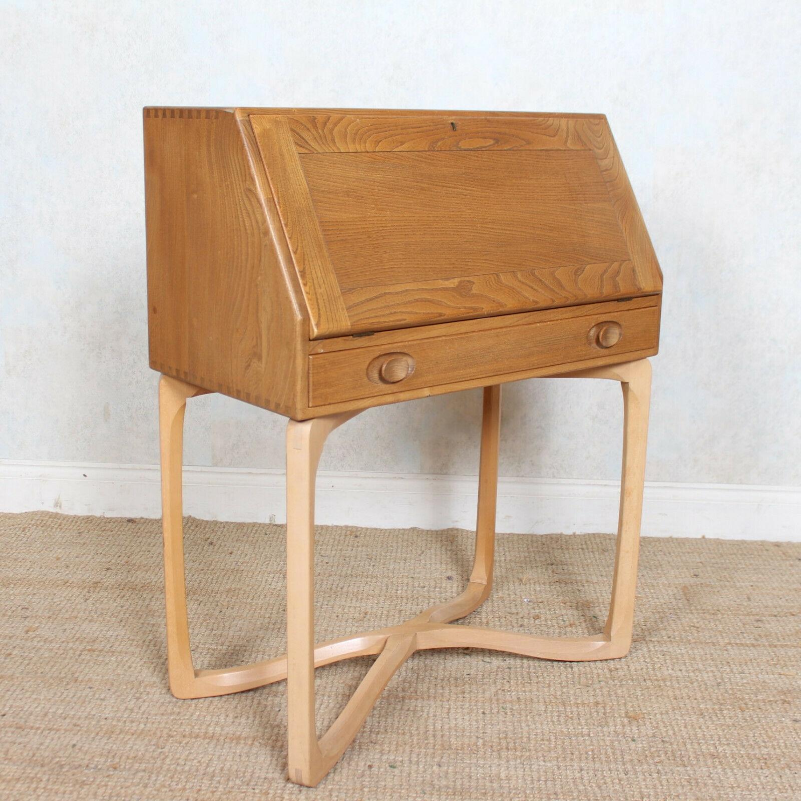 A rare opportunity to acquire an Ercol model 518 bureau.
The solid elm carcass boasting a well figured grain with sloping fall front enclosed pigeon holes and shelving above a long fitted drawer mounted with good handles, dovetailed jointing and