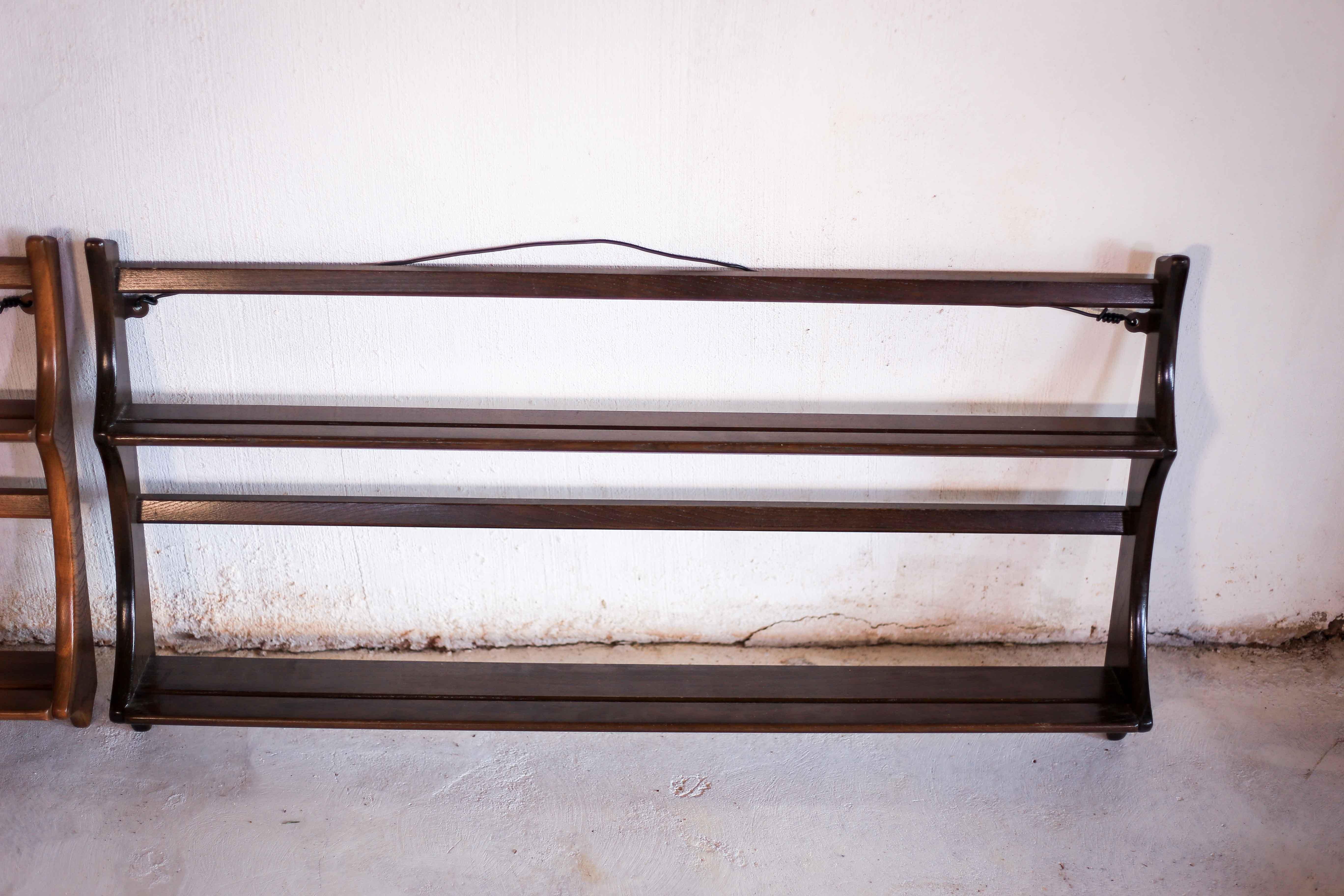 An vintage open plate rack for a wall with two plate heights from the 1950s. The build quality is very good, as can be expected from Ercol. It is made from solid English elm wood, with a dark finish. It is easy to hang on the two brackets. It also