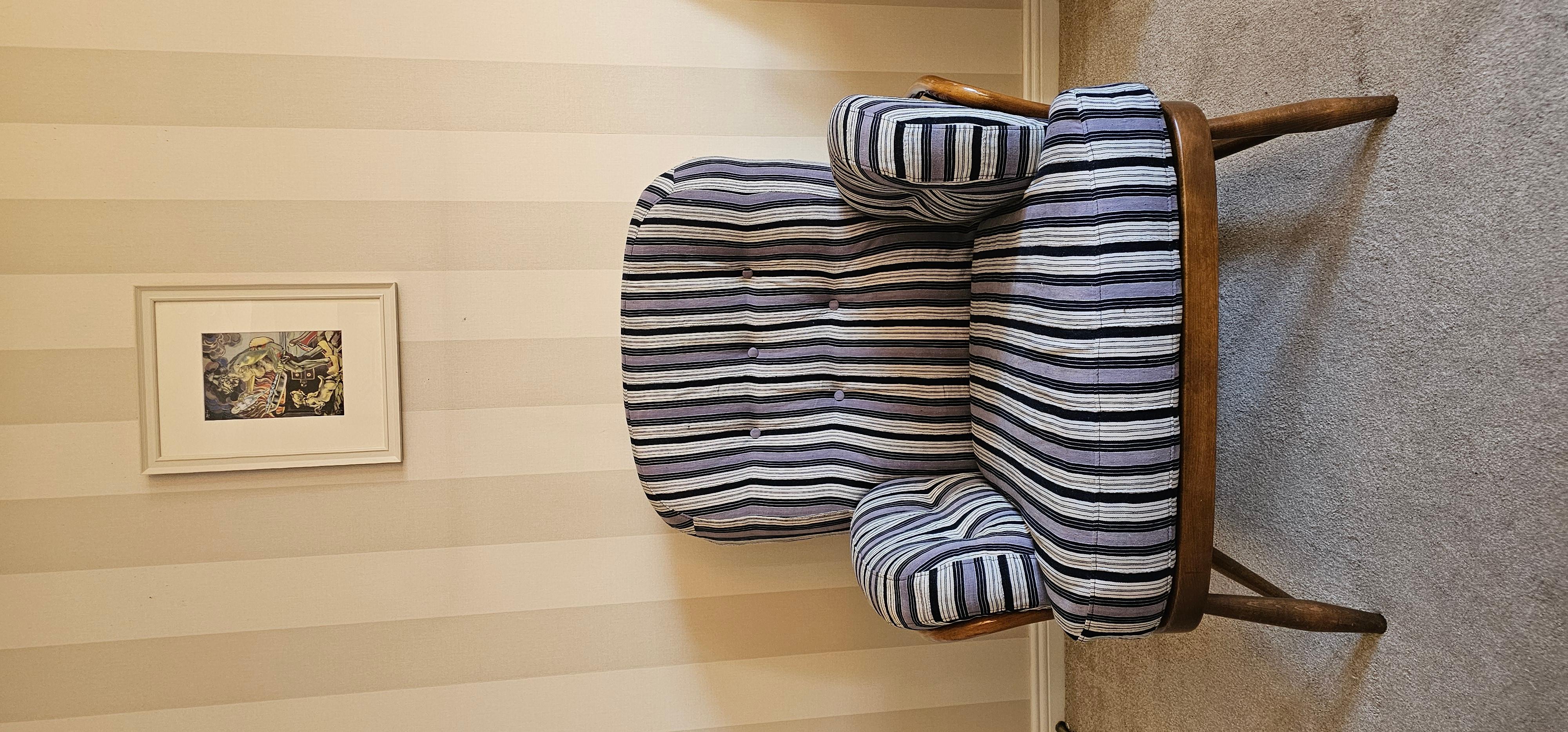 This is a very fine example of a 1970's Ercol armchair in very fine condition. The piece has been recovered in 1960's Ewe textile from the Volta region of Ghana . The covering is woven from handspun cotton and natural dyes. 
The striped textile
