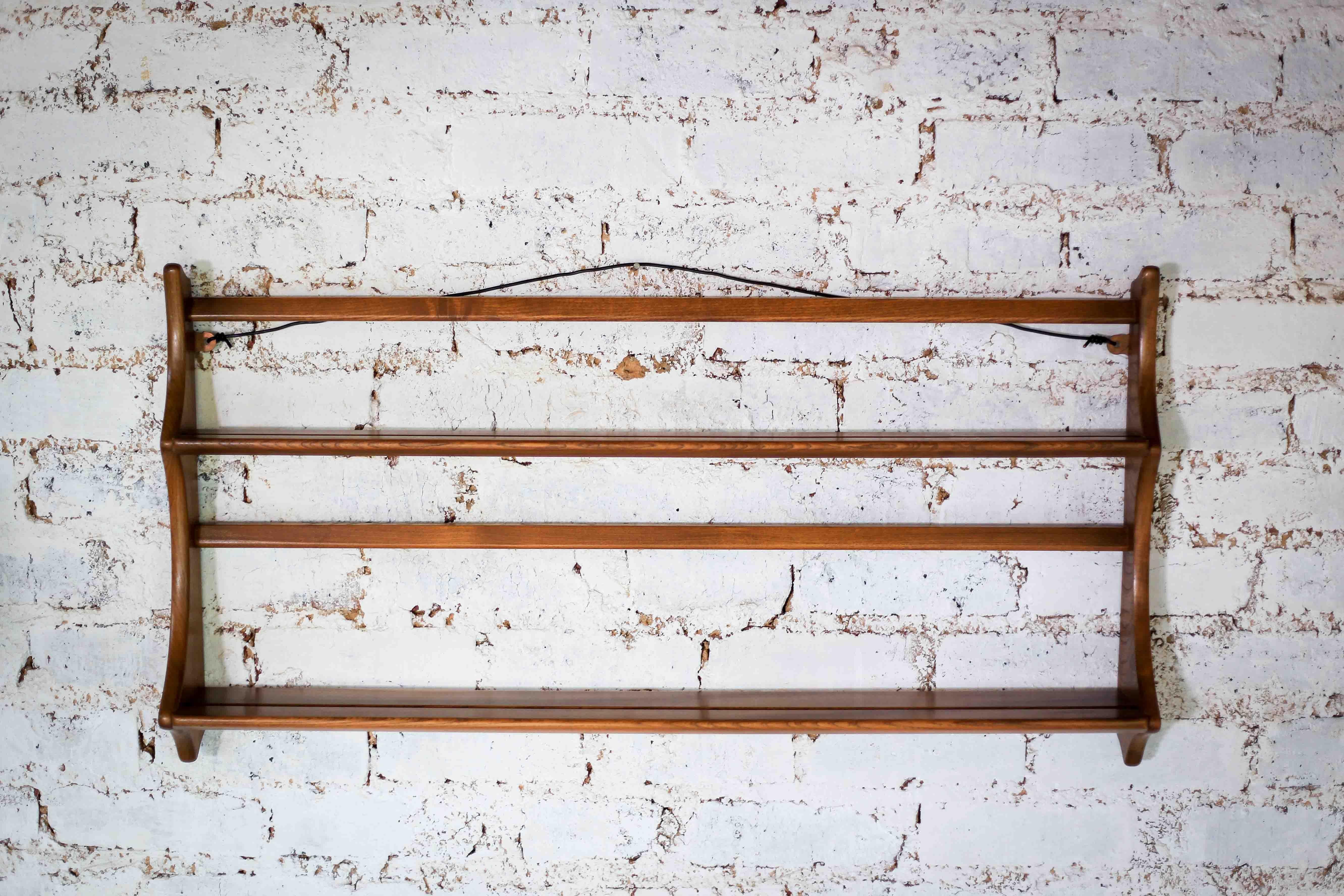 An vintage open plate rack for a wall with two plate heights from the 1950s. The build quality is very good, as can be expected from Ercol. It is made from solid English elm wood, finished in golden dawn. It is easy to hang on the two brackets. It