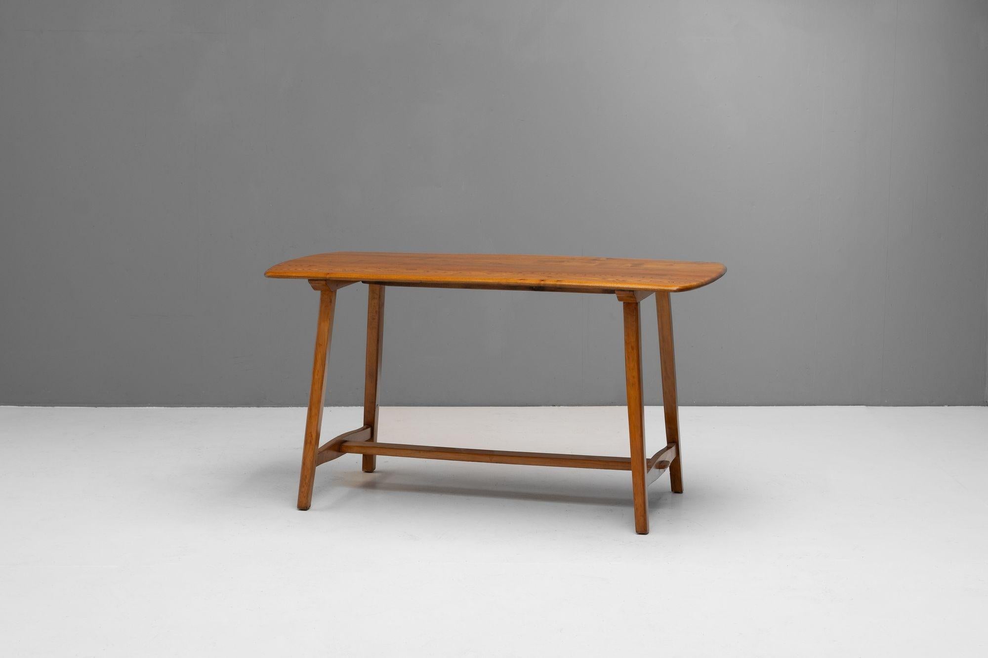 Mid-Century Ercol Plank table with stretcher in elm and beech. Re-finished. U.K circa 1960.

H 74cm (AH 72cm) x W 137cm x D 68cm

Please be in touch for an accurate shipping quote.