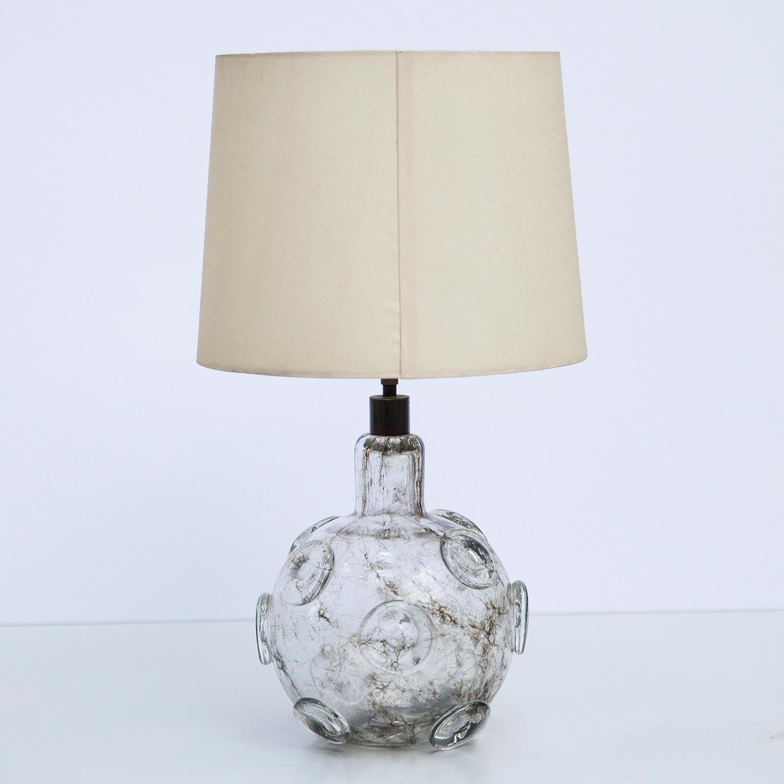 Small table lamp with massive glass and brown color obtained with ashes of steel wool. Applied clear glass medallions with original linen shade. Designed by Ercole Barovier, Italy, 1930s

Literature: Helmut Ricke, Eva Schmitt (Hrsg.),