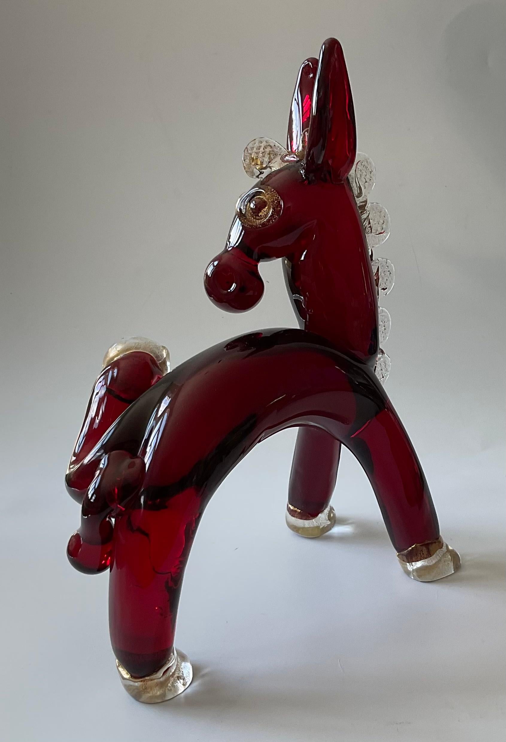 
Ercole Barovier für Barovier und Toso Seltene Murano-Glasskulptur eines Esels in leuchtendem Rot mit Goldapplikationen. Das Bein ist hoch. Seltene Art-Déco-Skulptur. 

Die fast fünfzigjährige Amtszeit von Ercole Barovier als künstlerischer Leiter,