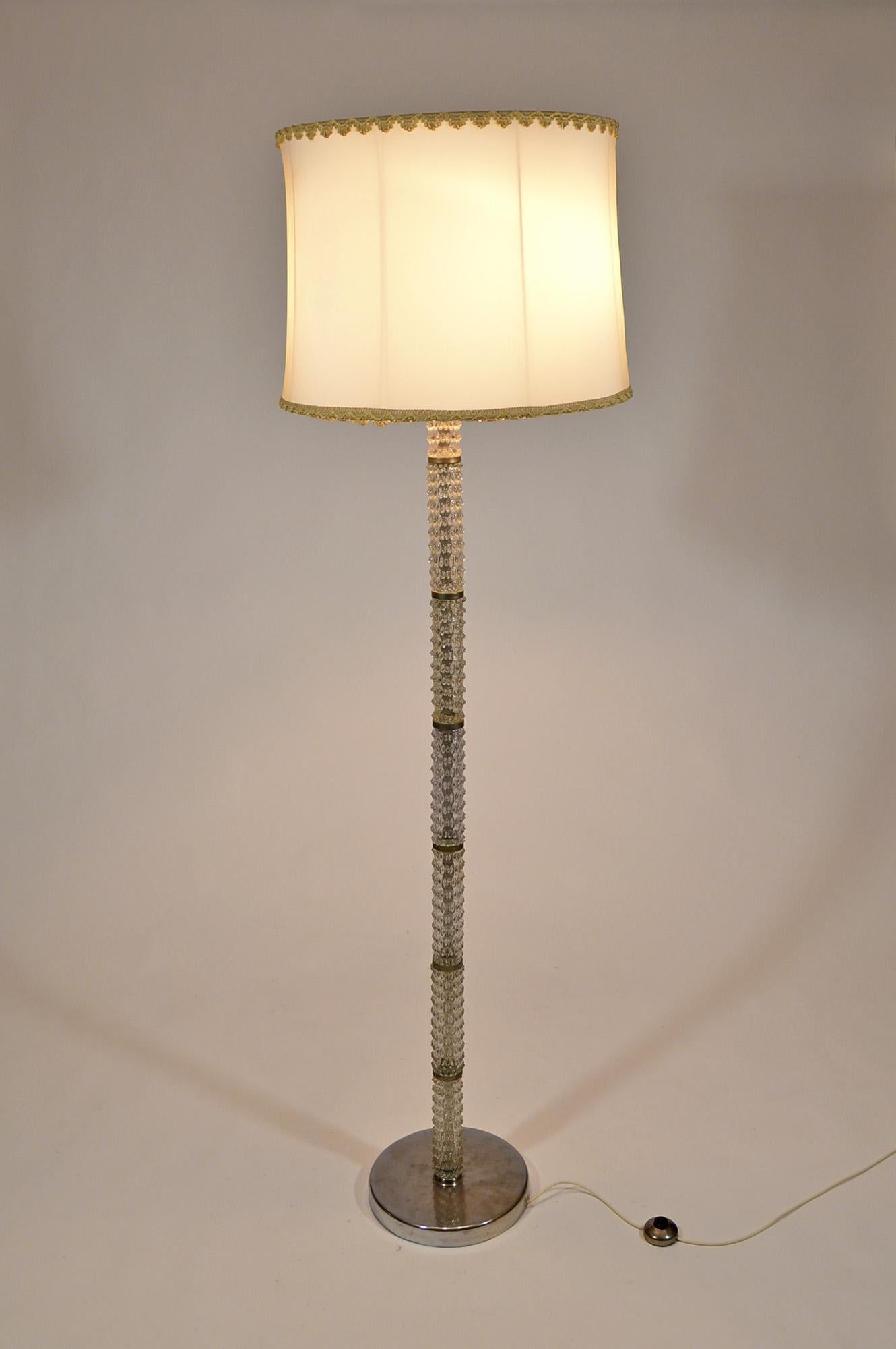 An Italian floor lamp designed by Ercole Barovier for Barovier & Toso, circa 1940, with chromed metal structure and Murano glass stem. The lamp is in good vintage condition, apart from a lack of glass on the first element of the stem, near the