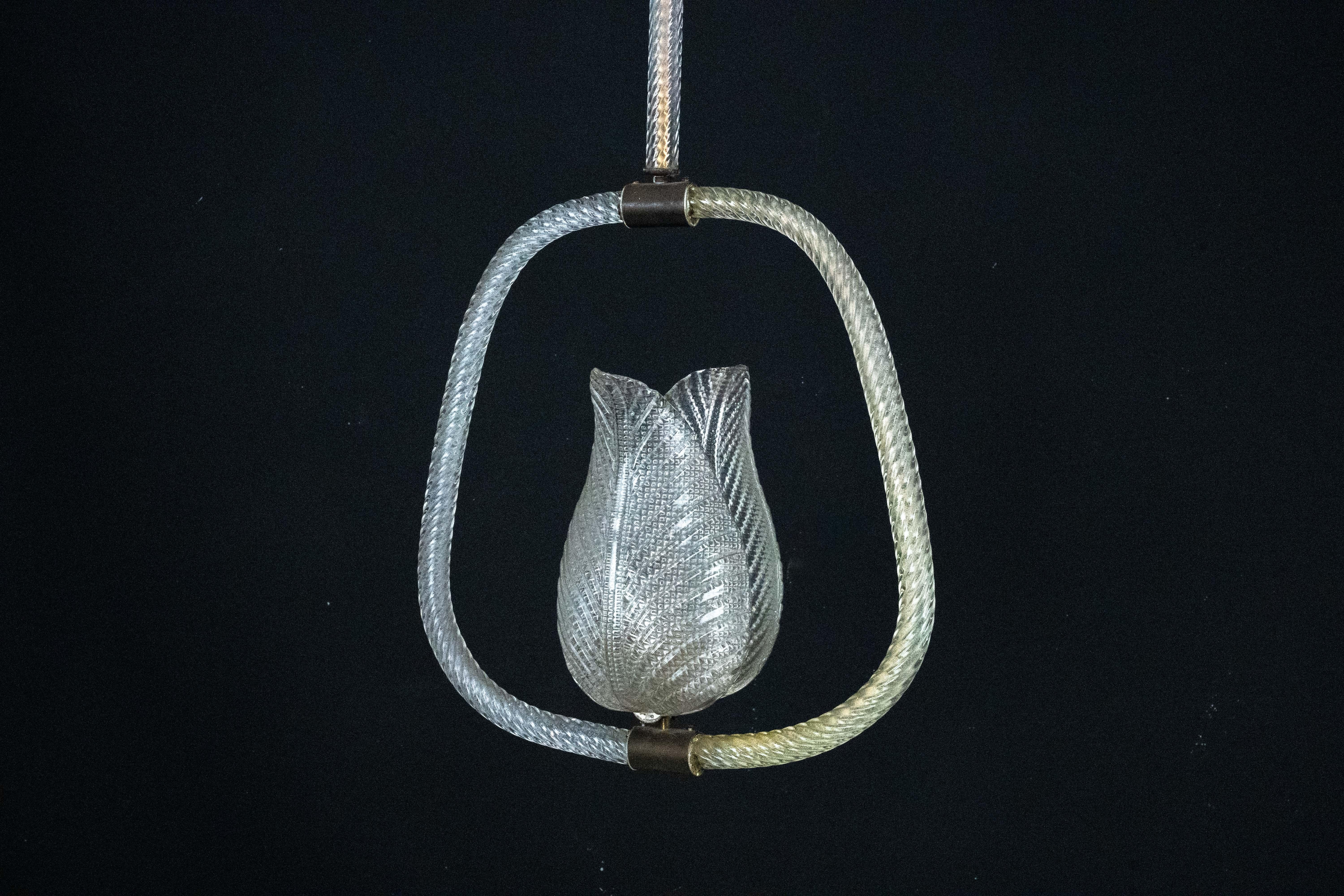 Lámpara de suspensión de cristal de Murano, obra de Ercole Barovier y fabricada en Italia durante la década de 1940. Este candelabro, refinado ejemplo de la artesanía de Murano de mediados de siglo, presenta una escultural pantalla de cristal