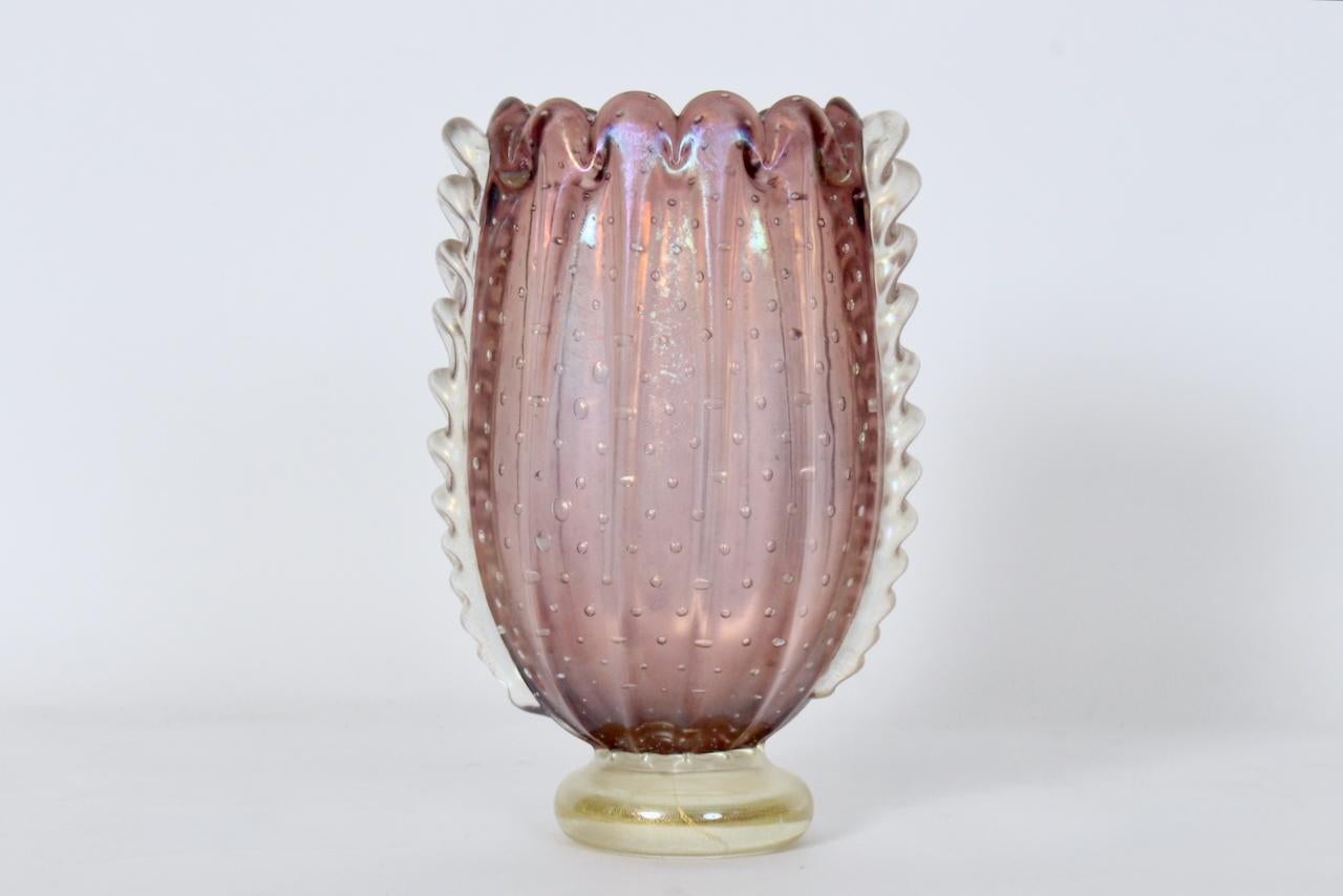 Vaso di Corusco in vetro di Murano rosa e trasparente di Ercole Barovier&Toso. Caratterizzato da una forma artigianale a coste verticali, apertura smerlata, in vetro di Murano traslucido Dusty Pink Lavender (Pantone 5145C), effetto bolla trasparente