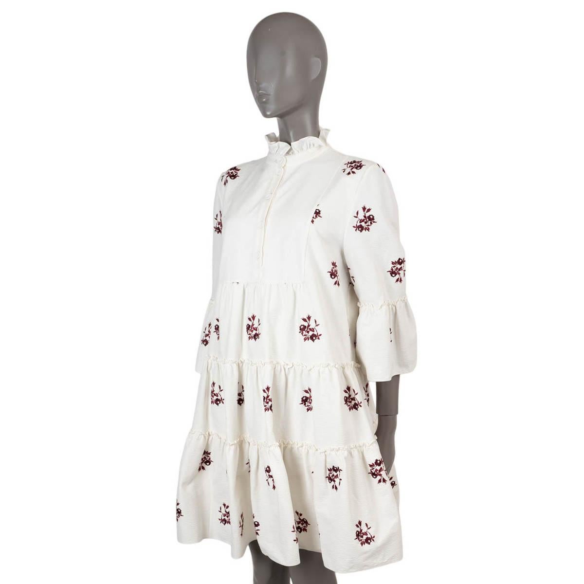 100% authentic Erdem Wyn tiered shirt dress in white cotton (99%) and elastane (1%). Features a ruffled mock neck, 3/4-sleeves, and red floral embroideries. Opens with four buttons on the front. Lined in cotton (100%). Has been worn and is in