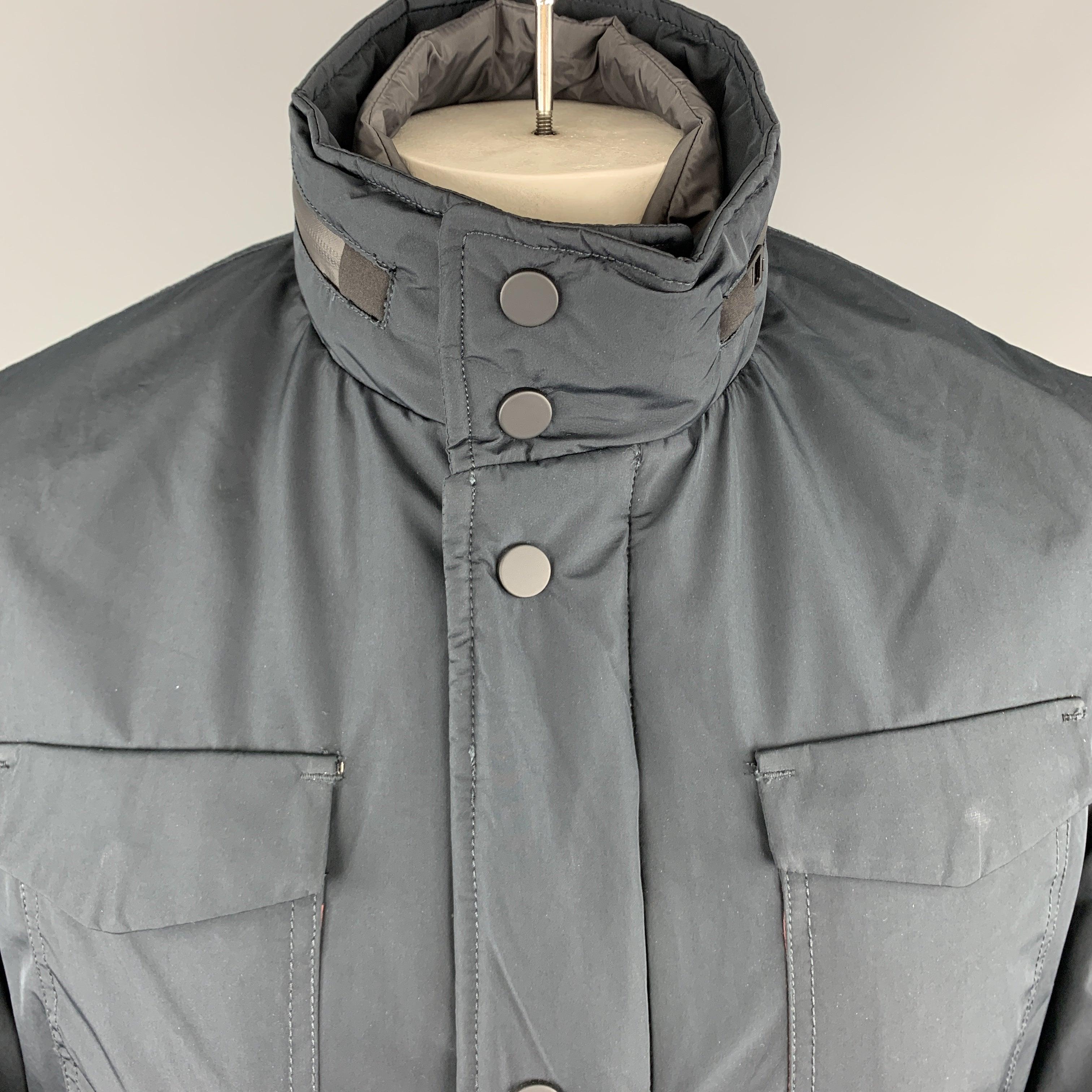 EREDI PISANO jacket comes in a navy waterproof fabric with a zip up snap placket closure, patch flap pockets, waterproof zippers, high collar with tight zip out hood, and detachable front panel. Made in Italy.New With Tags.  

Marked:   50