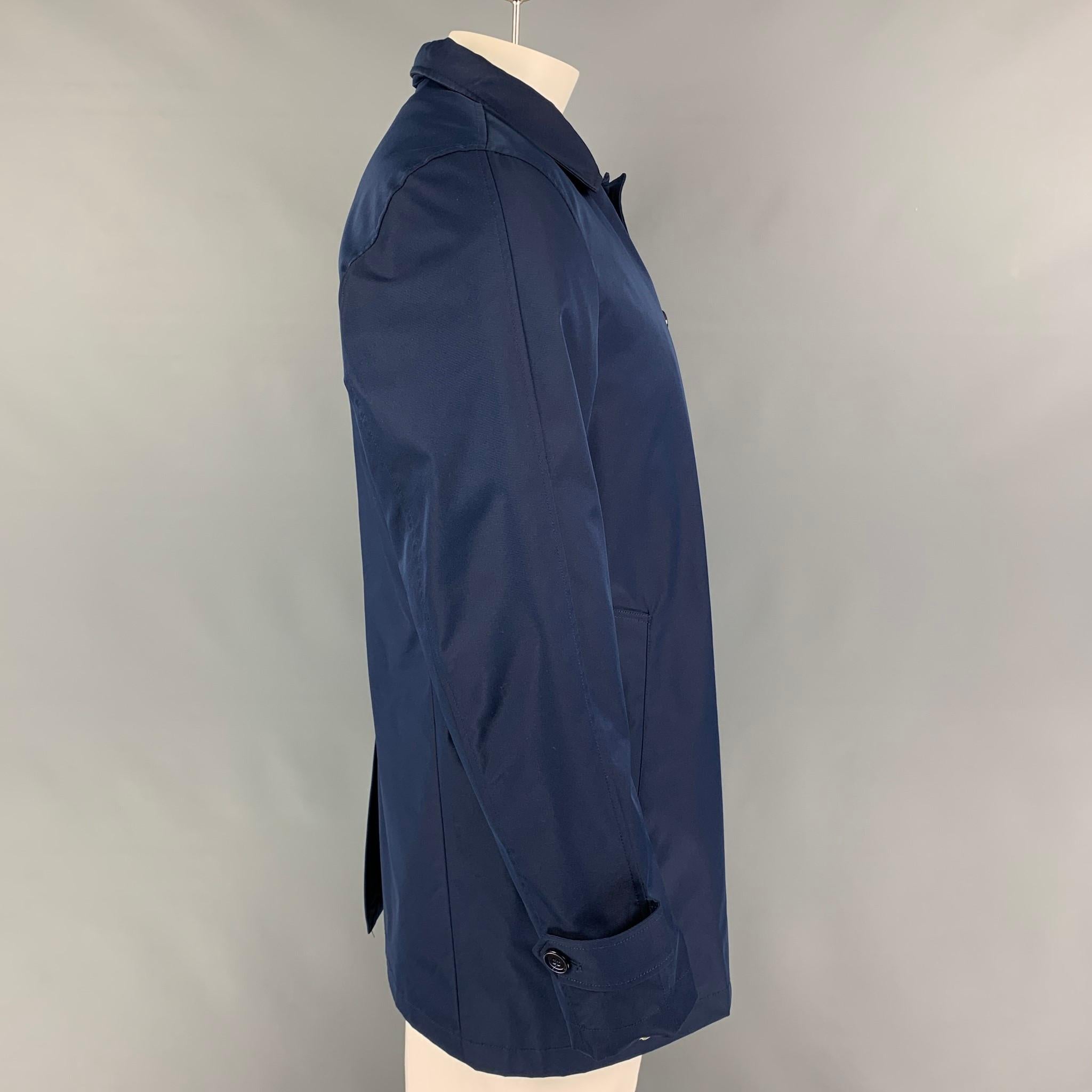 EREDI PISANO coat comes in a navy cotton with a detachable liner featuring a hooded style, slit pockets., single back vent, and a buttoned closure. 

Very Good Pre-Owned Condition.
Marked: 52

Measurements:

Shoulder: 18.5 in.
Chest: 44 in.
Sleeve: