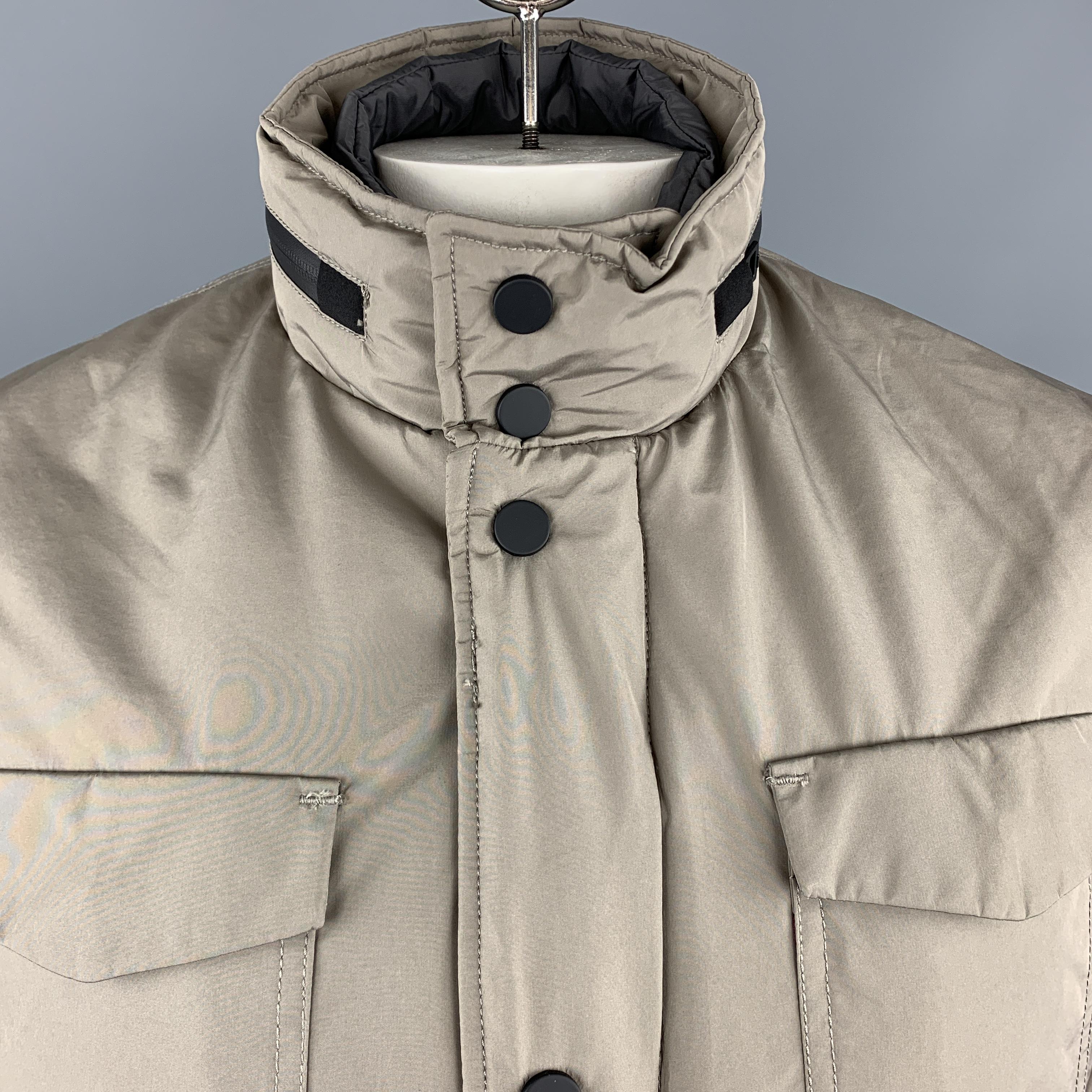 EREDI PISANO jacket comes in a khaki beige waterproof fabric with a zip up snap placket closure, patch flap pockets, waterproof zippers, high collar with tight zip out hood, and detachable front panel. Made in Italy.

New With Tags. 
Marked:
