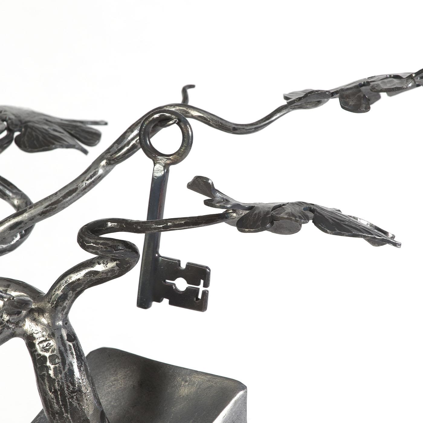 An evoking sculpture of fascinating mystery, this beaten iron design juxtaposes a clean and sturdy aesthetic with a surreal and complex symbolic meaning, embedded in an unexplored, inner reality. Handcrafted, it is finished with a transparent