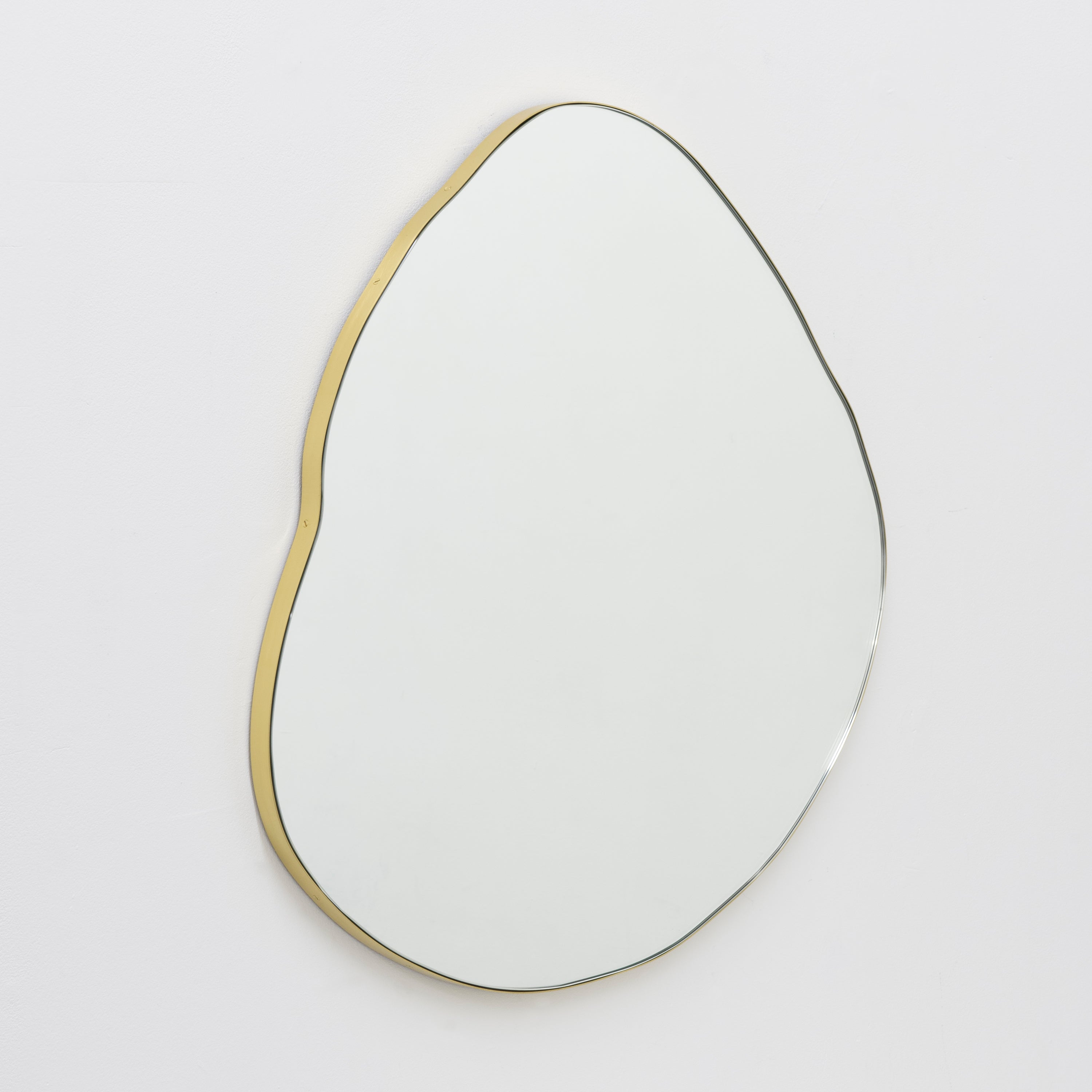 Playful and modern organic shaped mirror with a solid brass brushed frame.

Fitted with a brass hook or an aluminium z-bar (depending on the size of the mirror) that allow for the mirror to be hanged in four different positions. Also available on