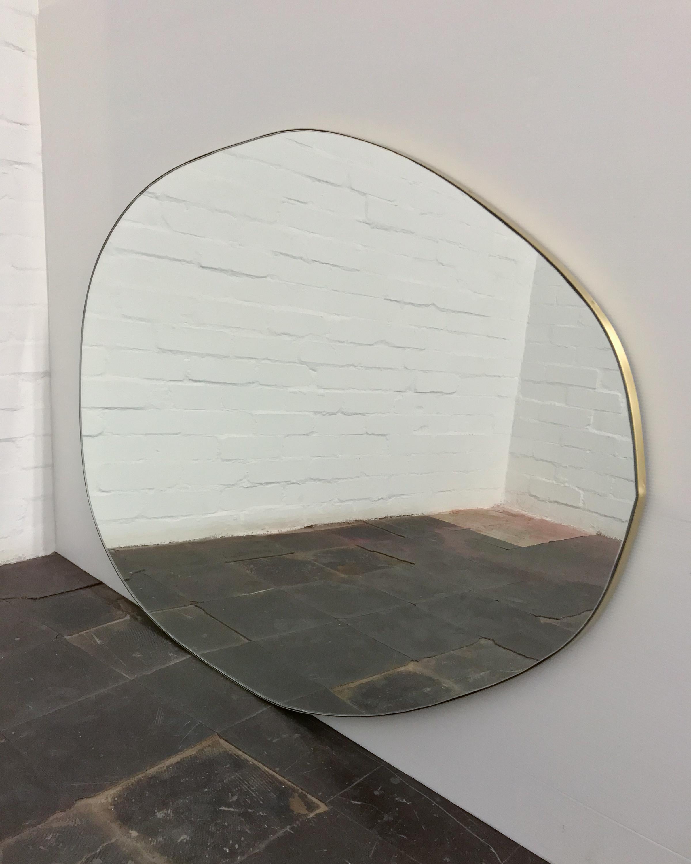 Nuva™ playful and modern organic shaped mirror with a solid brass brushed frame. Designed and made in London, UK.

Our mirrors are designed with an integrated French cleat (split batten) system that ensures the mirror is securely mounted flush with