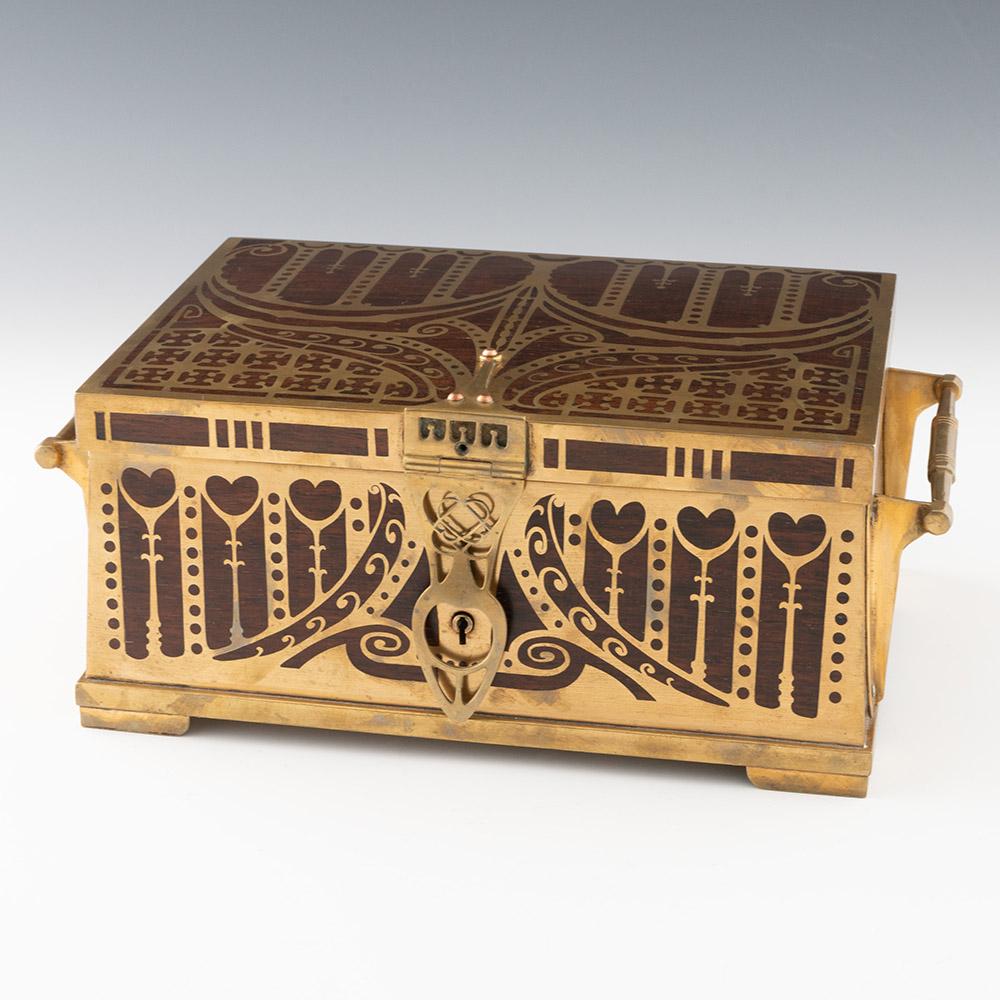 Heading : Erhard and Sohne Art Nouveau jewellery casket c1900

Period : Turn of the century

Origin : Germany

Decoration : Brass inlaid rosewood with various stylised designs reminiscent of British Arts & Crafts.  Two handles, working lock and key