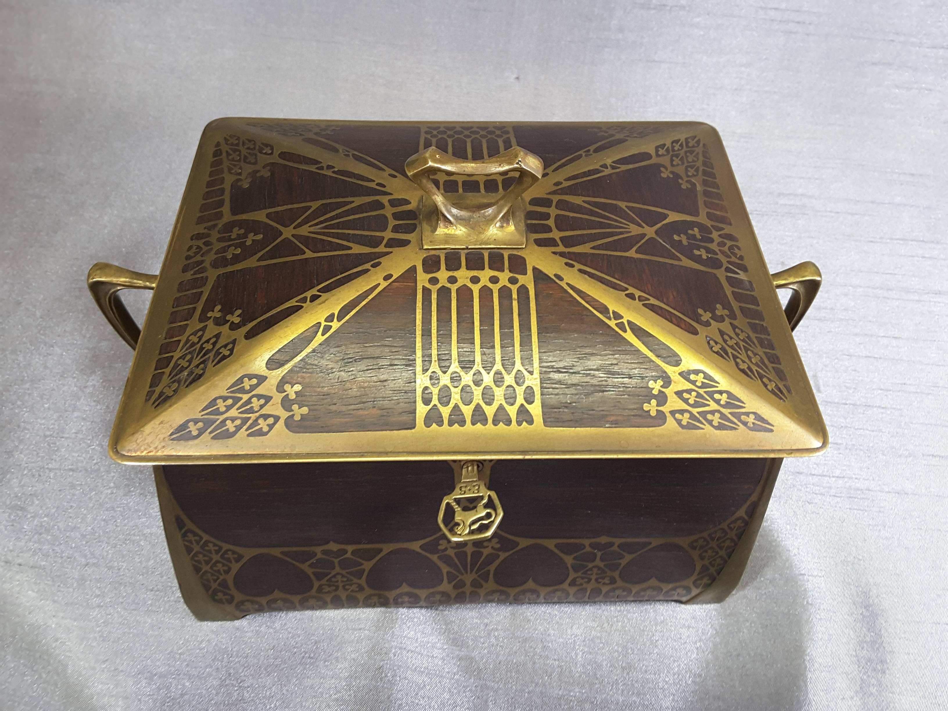 Erhard & Sohne (Erhard & Sons) Secession/Art Nouveau jewelry casket or box done in rosewood and brass, velvet lined interior. The casket is decorated with inverted hearts and clover leaves, brass has a nice patina, rosewood is in nice condition. The