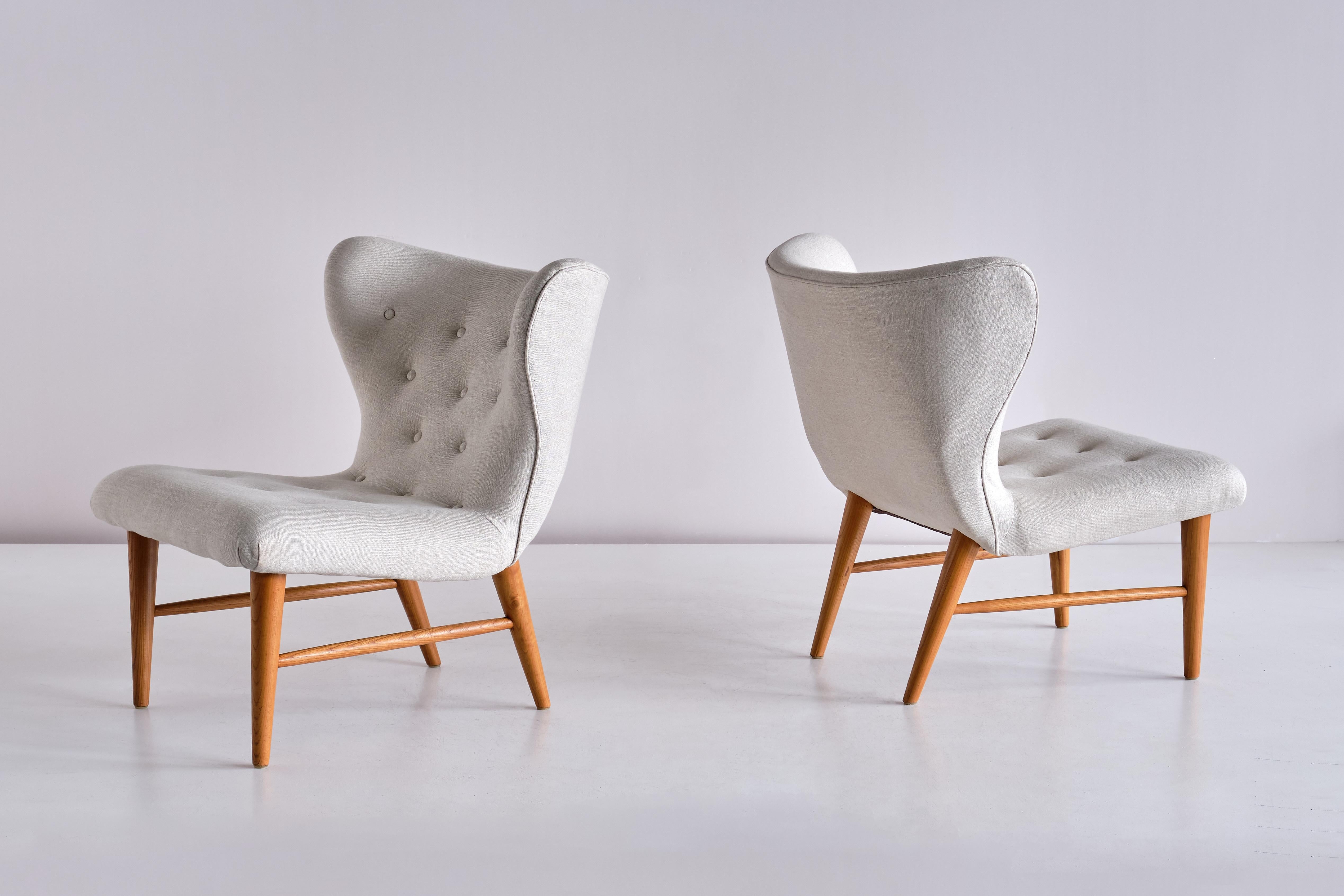 Dieses seltene Paar Loungesessel wurde von Eric Bertil Karlén entworfen und von seiner Firma Rumsinteriör in den 1940er Jahren in Schweden hergestellt. Die elegante Form des Designs wird durch die geknöpfte, flügelförmige Rückenlehne und Sitzfläche
