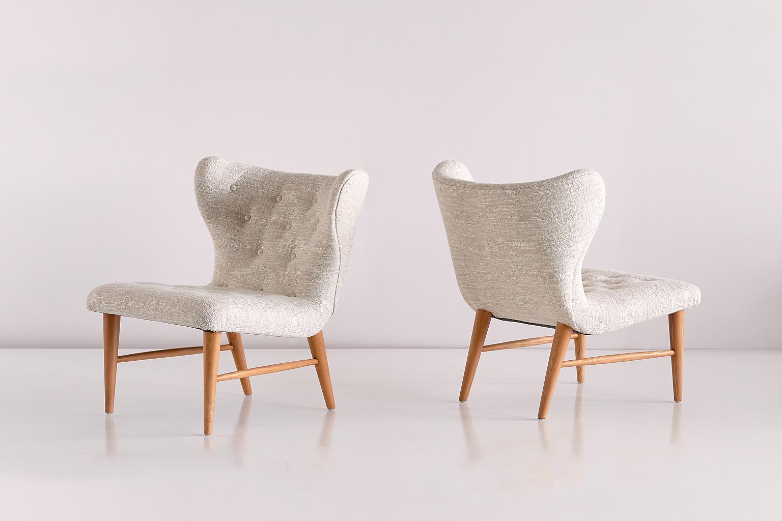 This rare pair of lounge chairs was designed by Eric Bertil Karlén and produced by his company Firma Rumsinteriör in Sweden in the 1940s. The elegant shape of the design is emphasized by the buttoned wing shaped back and seat. The elm wood frame
